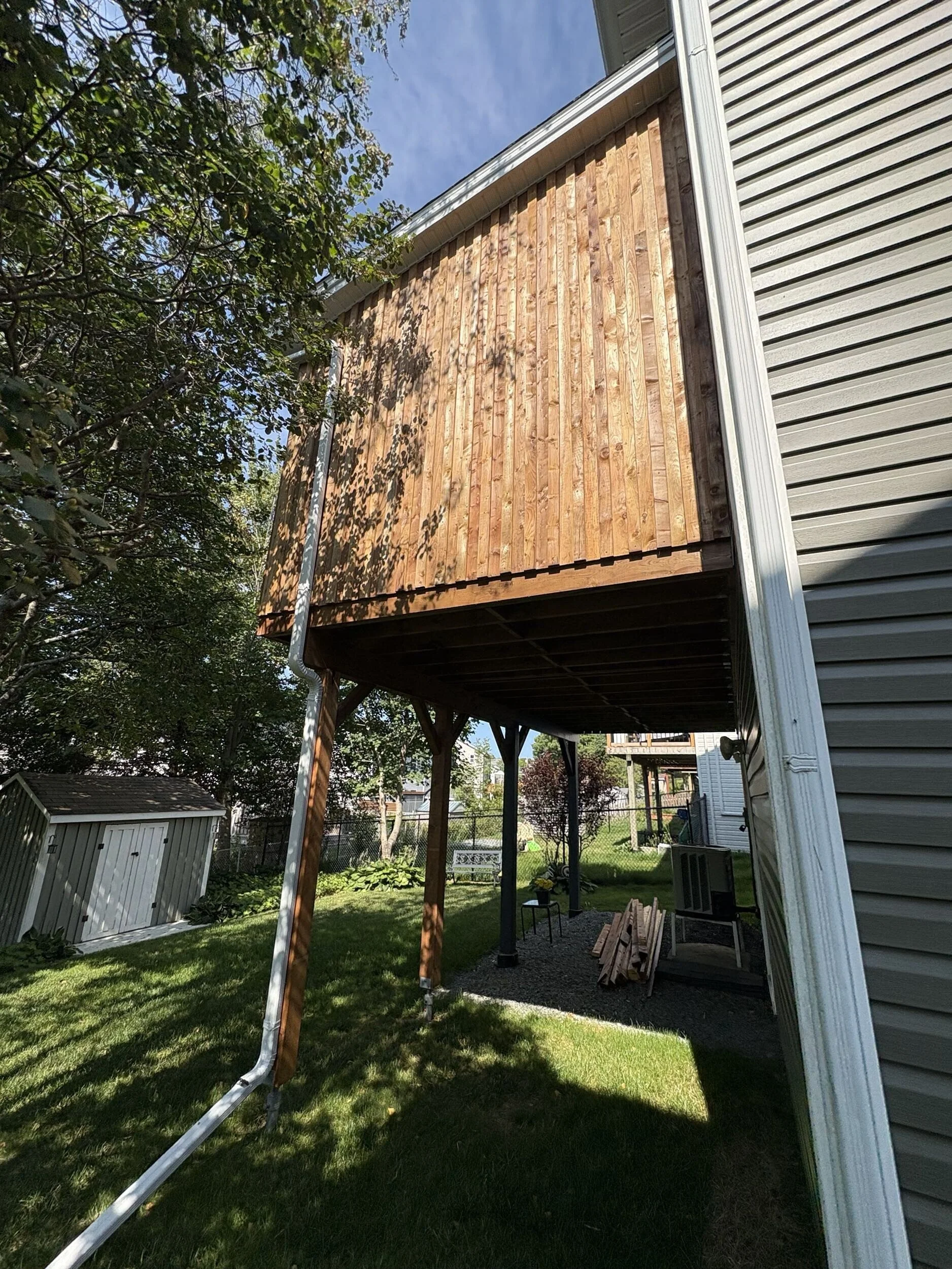 Exterior view of The Treehouse, a custom elevated screened deck addition built above a walkout basement in Halifax, Nova Scotia.