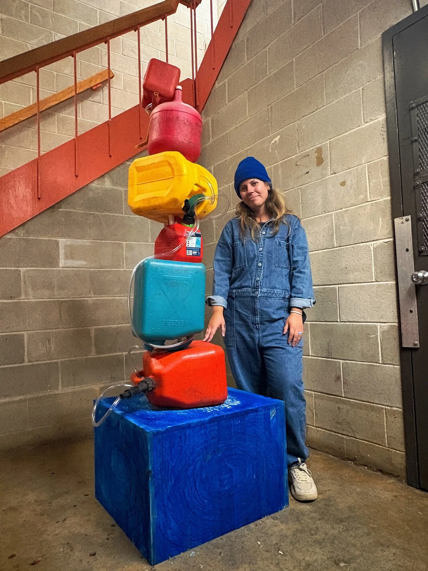 Christie Jones
Drill, Spill, Repeat
Fall 2025
Medium: Pine wood, wood glue, nails, natural pigment stains, found gasoline, diesel, 
and kerosene cans, plastic tubing, discarded shower curtain rod.

Christie Jones&rsquo; work explores climate change, 