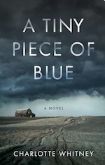 Book cover of A Tiny Piece of Blue by Charlotte Whitney. Image shows a dirt road leading to a remote cabin. The sky is a dark blue and gray