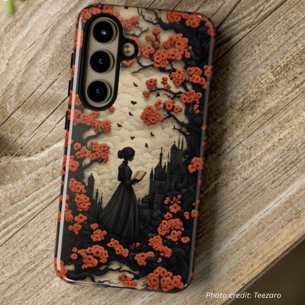 Woman Reading Halloween Phone Case by Teezaro. Shows a woman in 1800s clothing reading a book near dark black trees with bright orange flowers as leaves