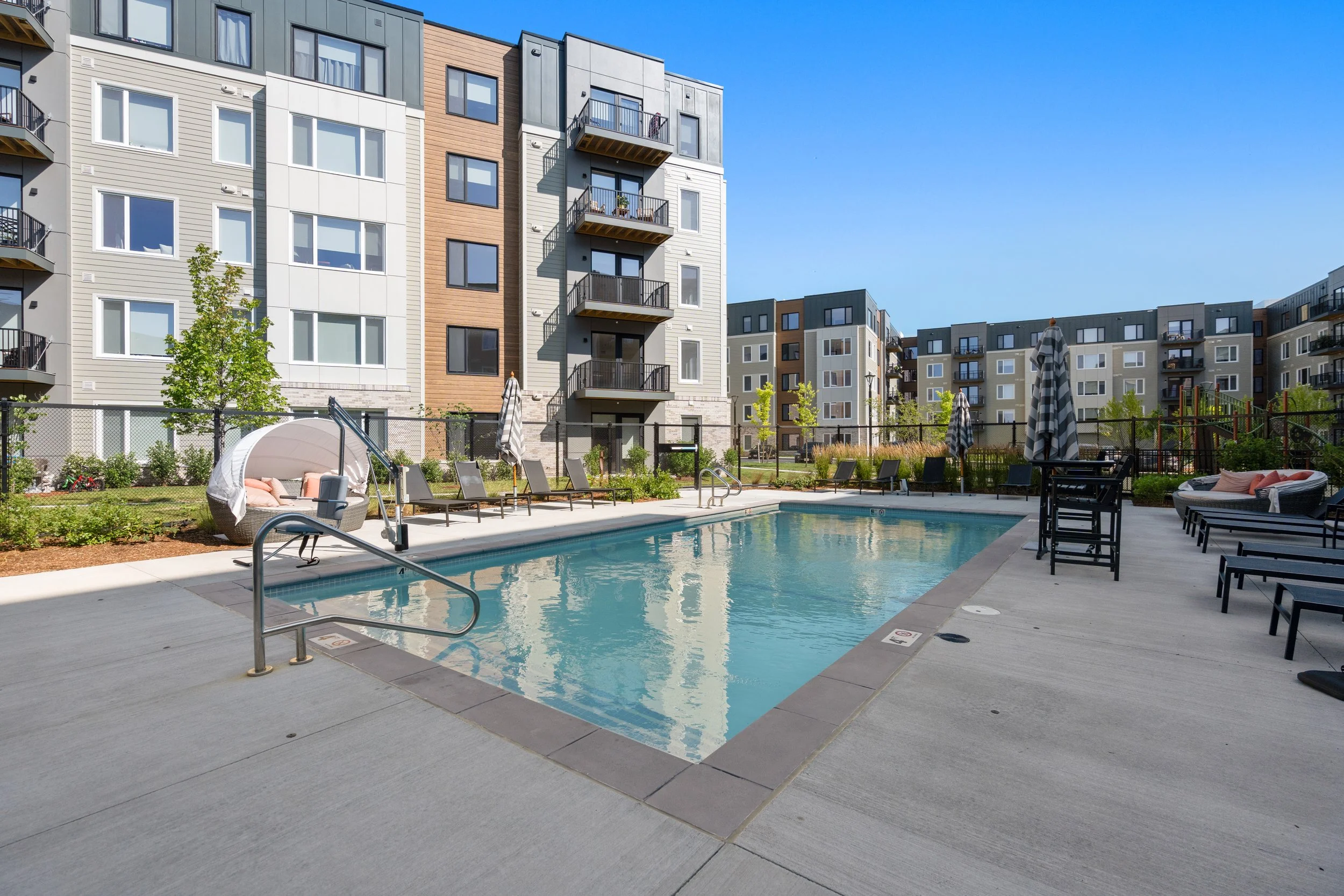 The Devon's swimming pool surrounded by comfortable lounge chairs and cabana spaces.