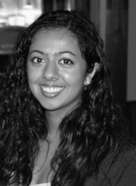 Black and white portrait of a smiling woman with curly hair.