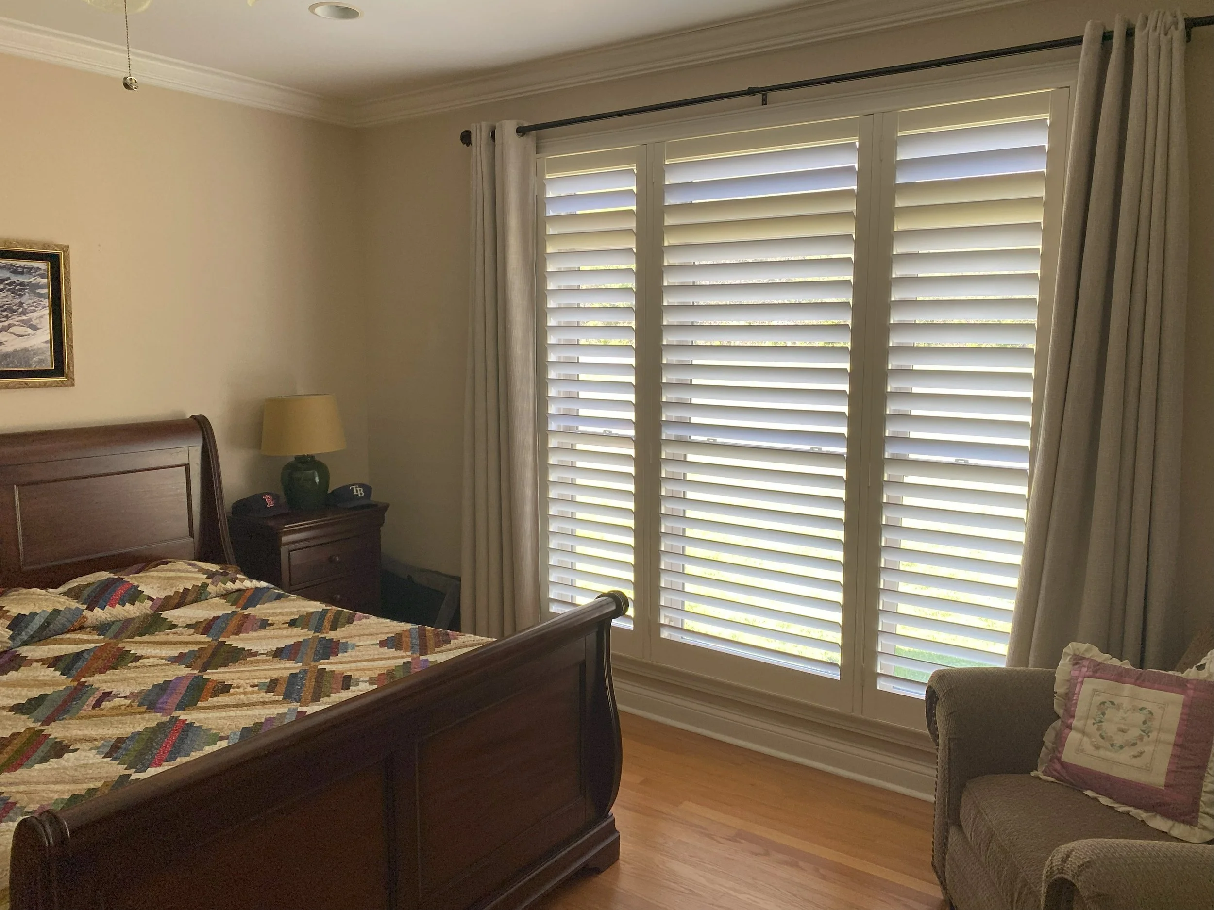 Master Bed triple panel Plantation Shutter pared with curtains
