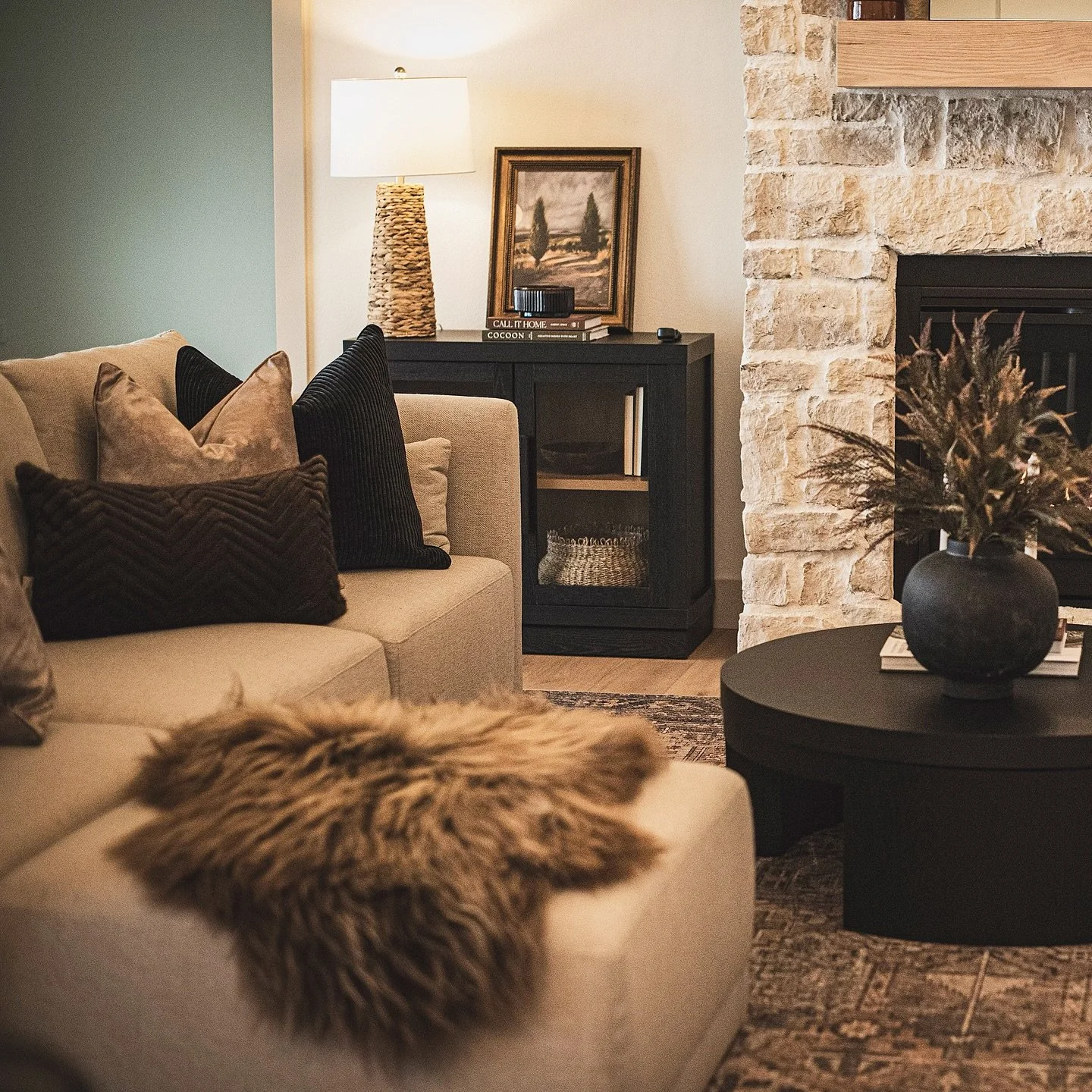 Earthy tones, sheepskin, loads of contrast,  and plenty of texture makes this space SO cozy + livable. Comfort is always the best luxury of them all. 🤎