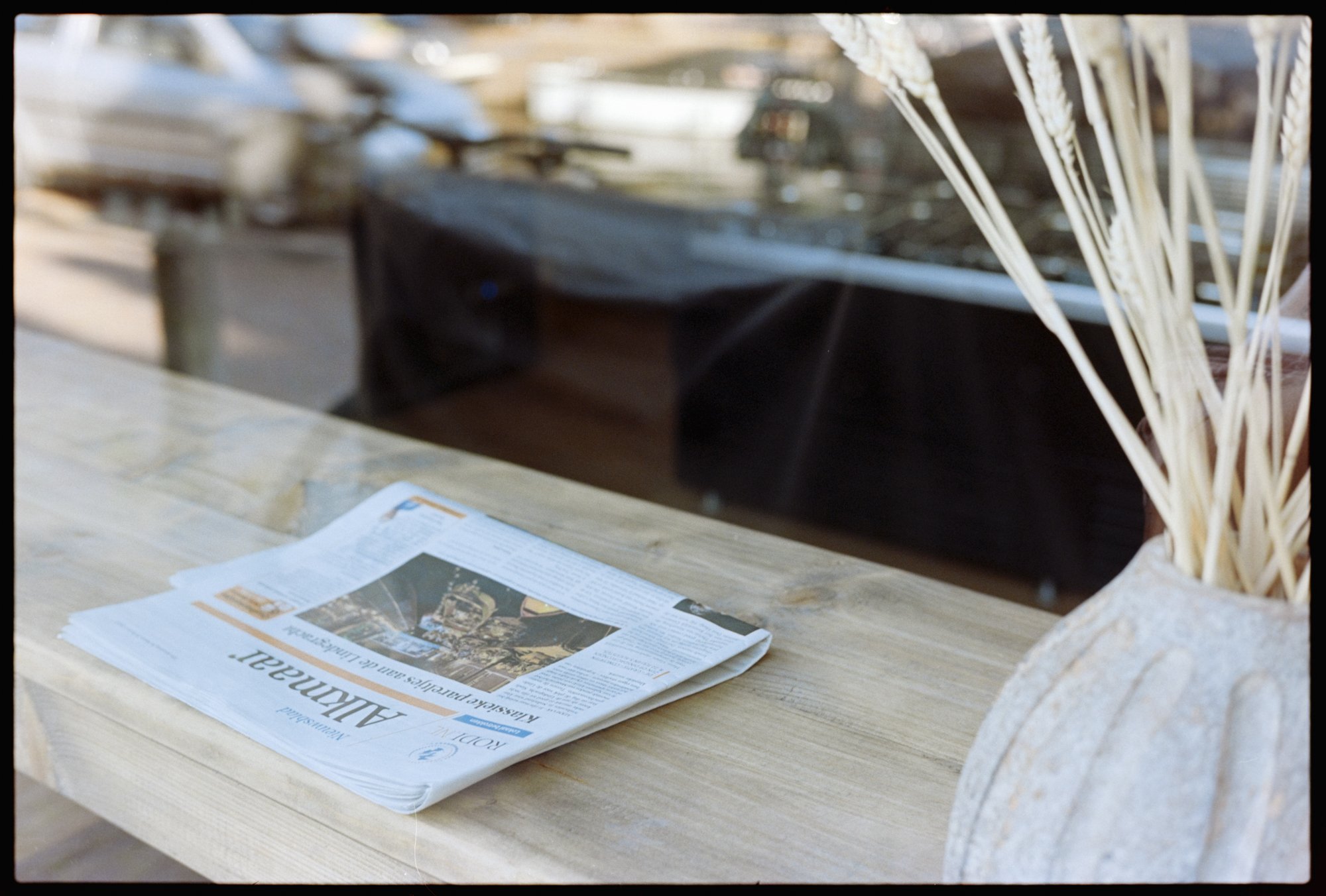 A copy of the Alkmaar newspaper sits in the window of a closed bakery.