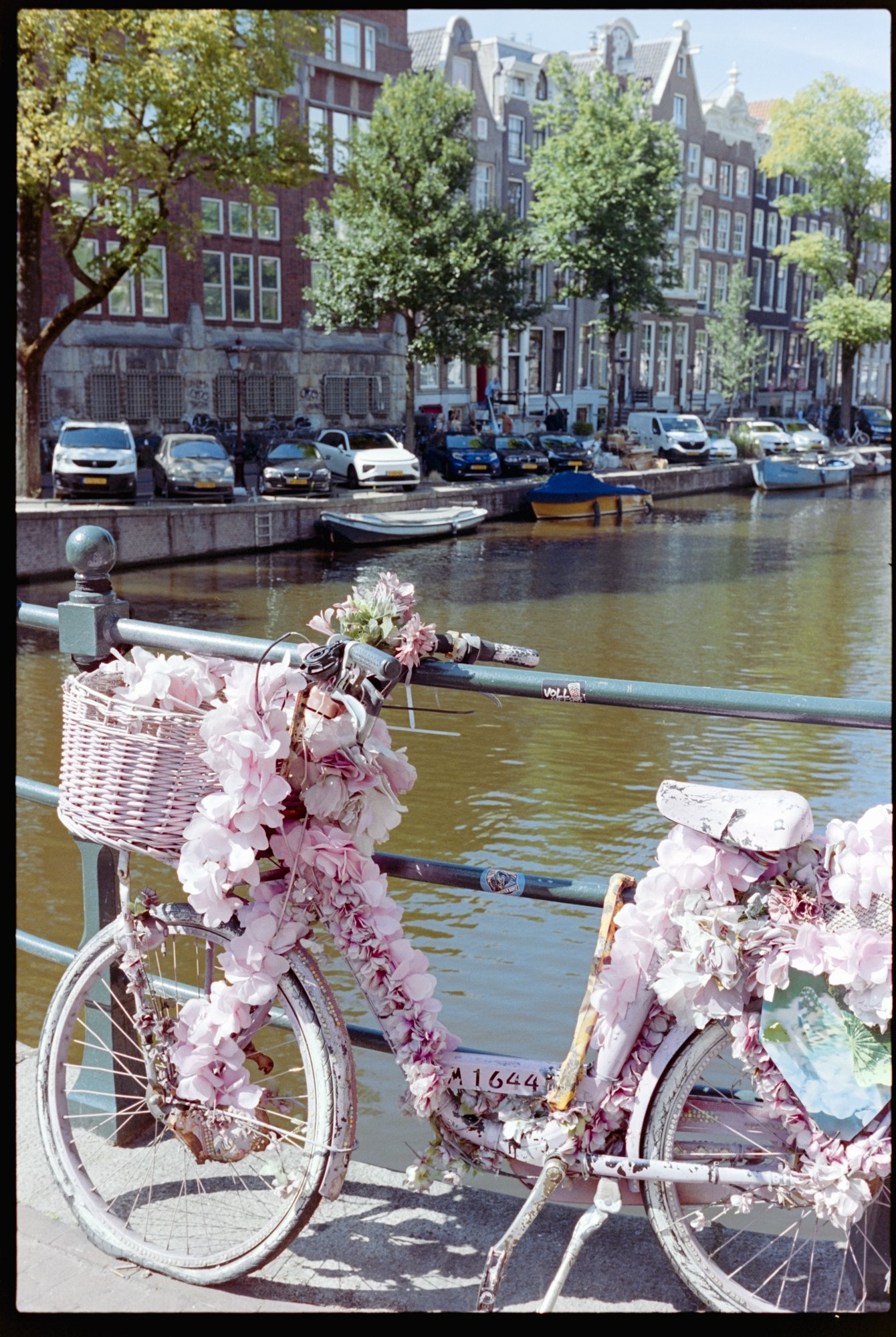 A bicycle covered in flowers on a bridge in Amsterdam.
