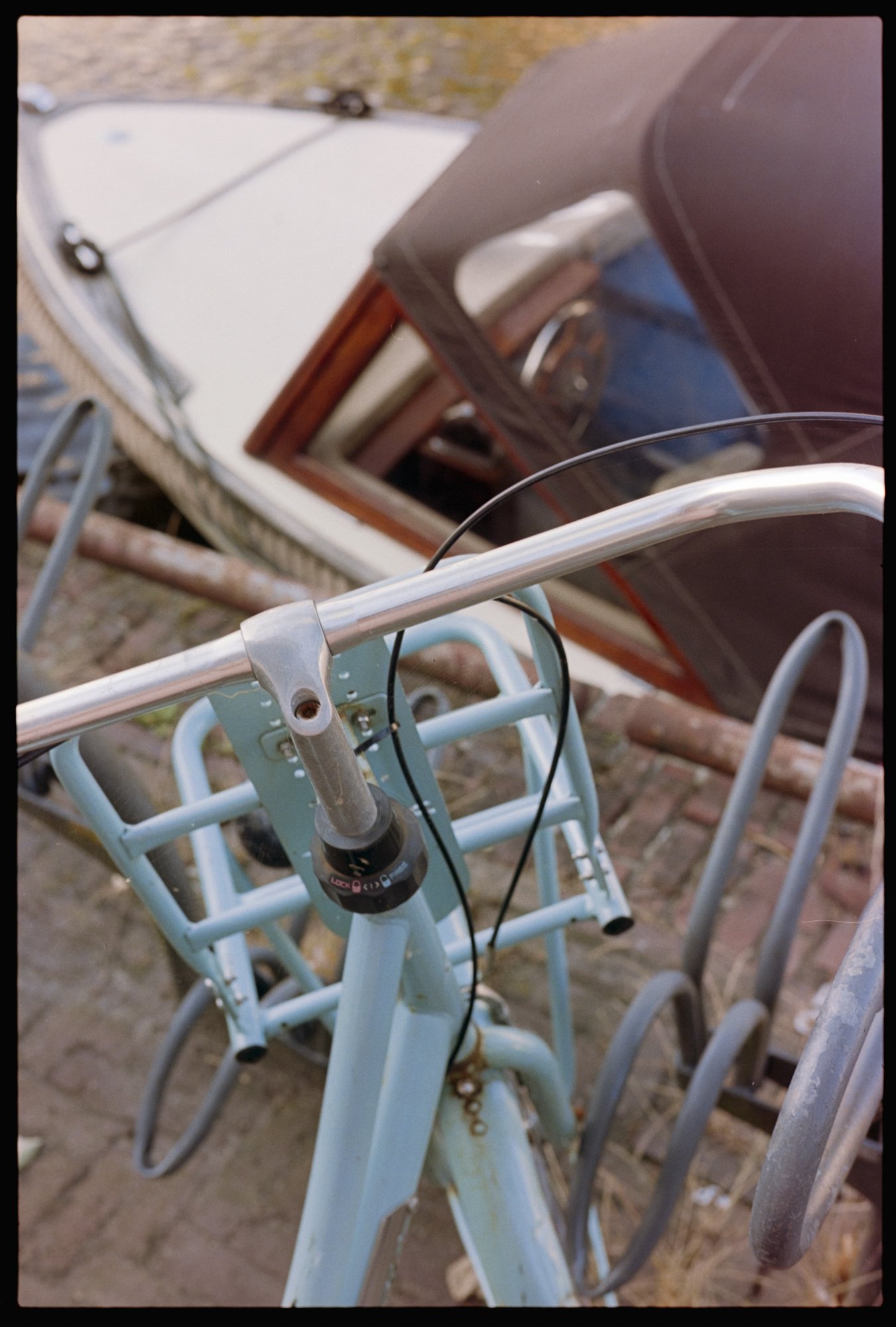 A bicycle sits on the bank of an Alkmaar, the Netherlands, canal above a boat.