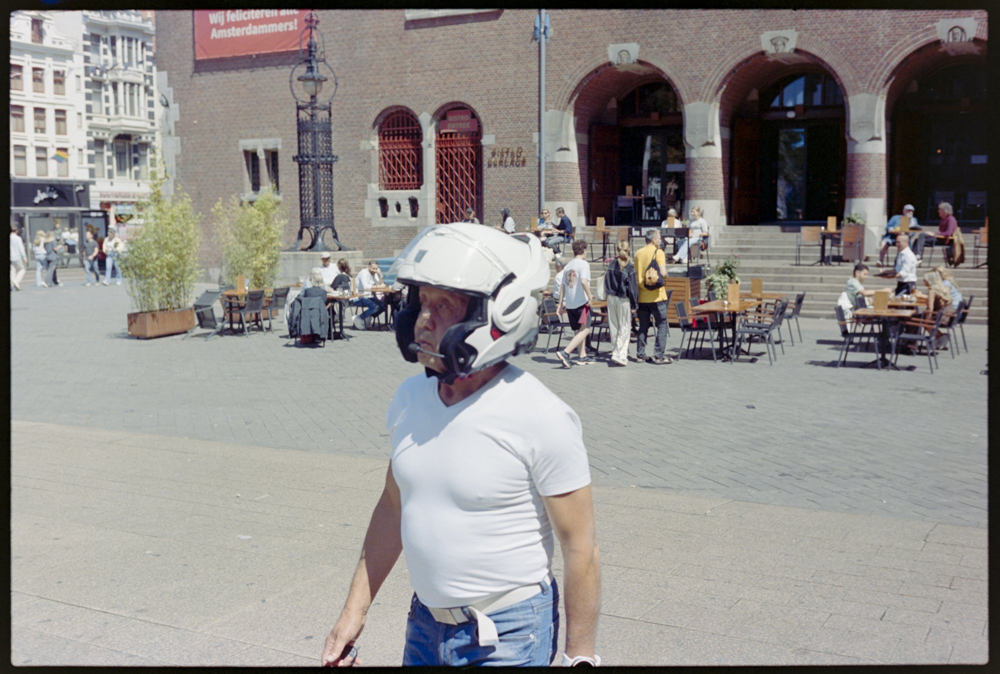 A man walks outside the Amsterdam stock exchange wearing his motorcycle helmet.