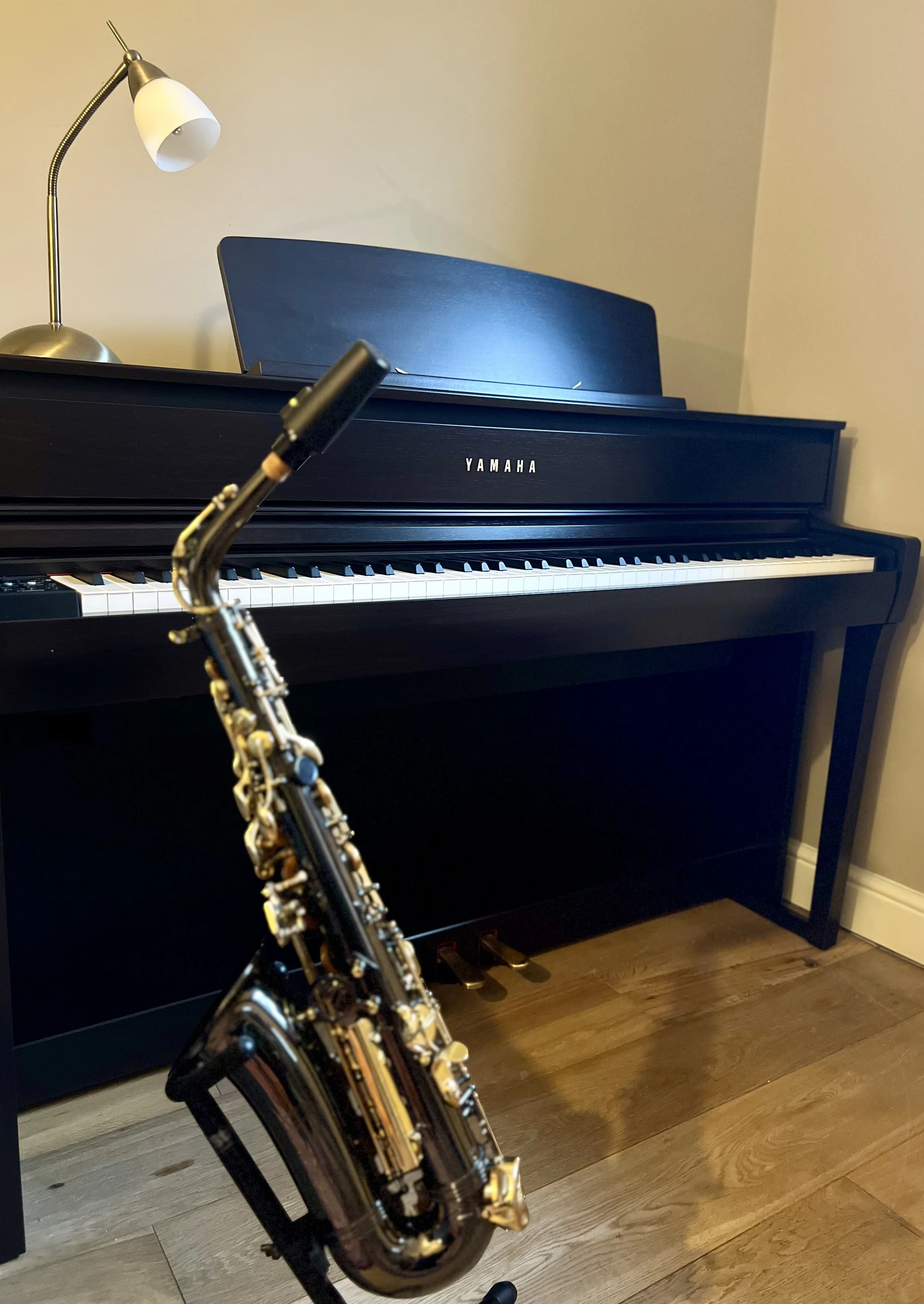 A picture of a piano and saxophone in the corner of Andy’s music room.