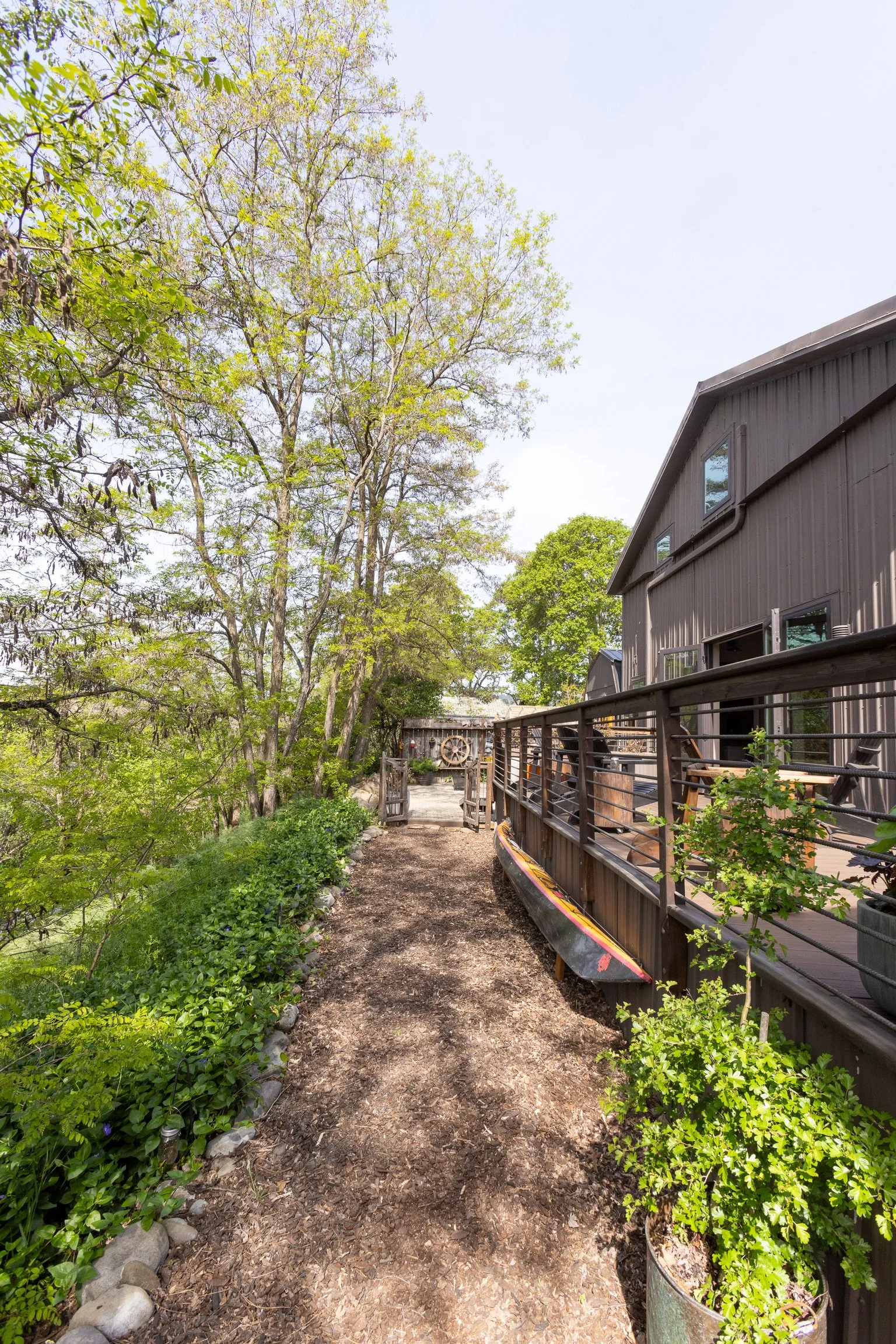 Interior of a cafe or restaurant with a large wooden table, small flower arrangements, and a gallery wall with geometric shapes and art.