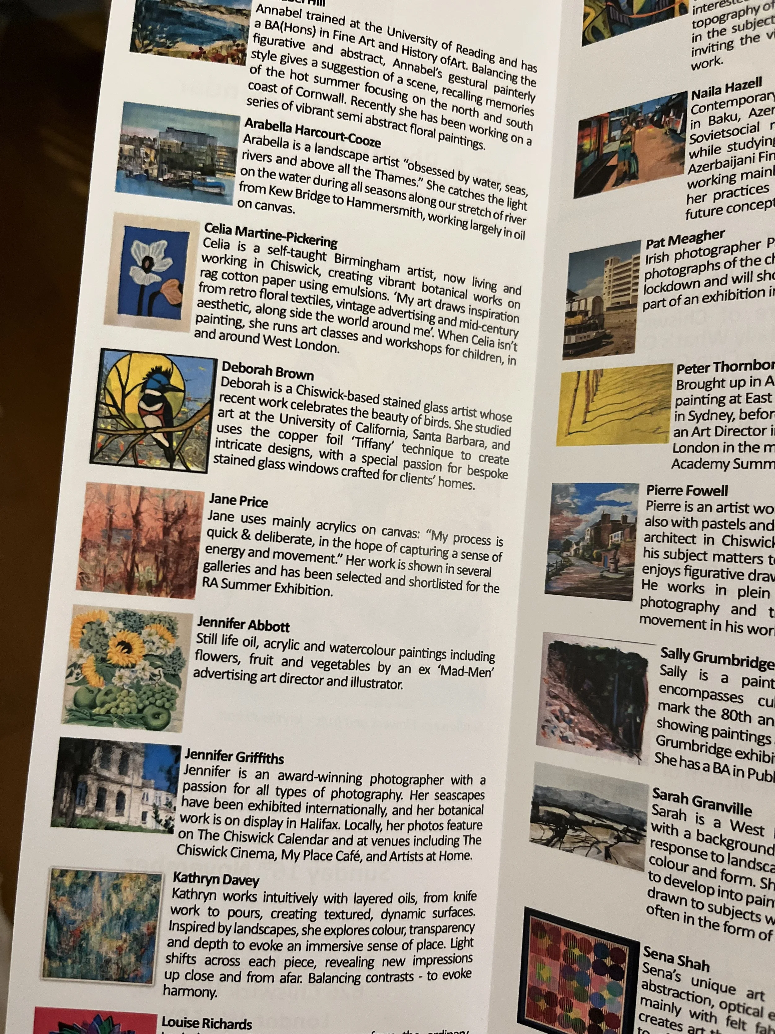 A close-up of a printed page featuring descriptions and images of various artists' works, including paintings and illustrations, and a stained glass bird.