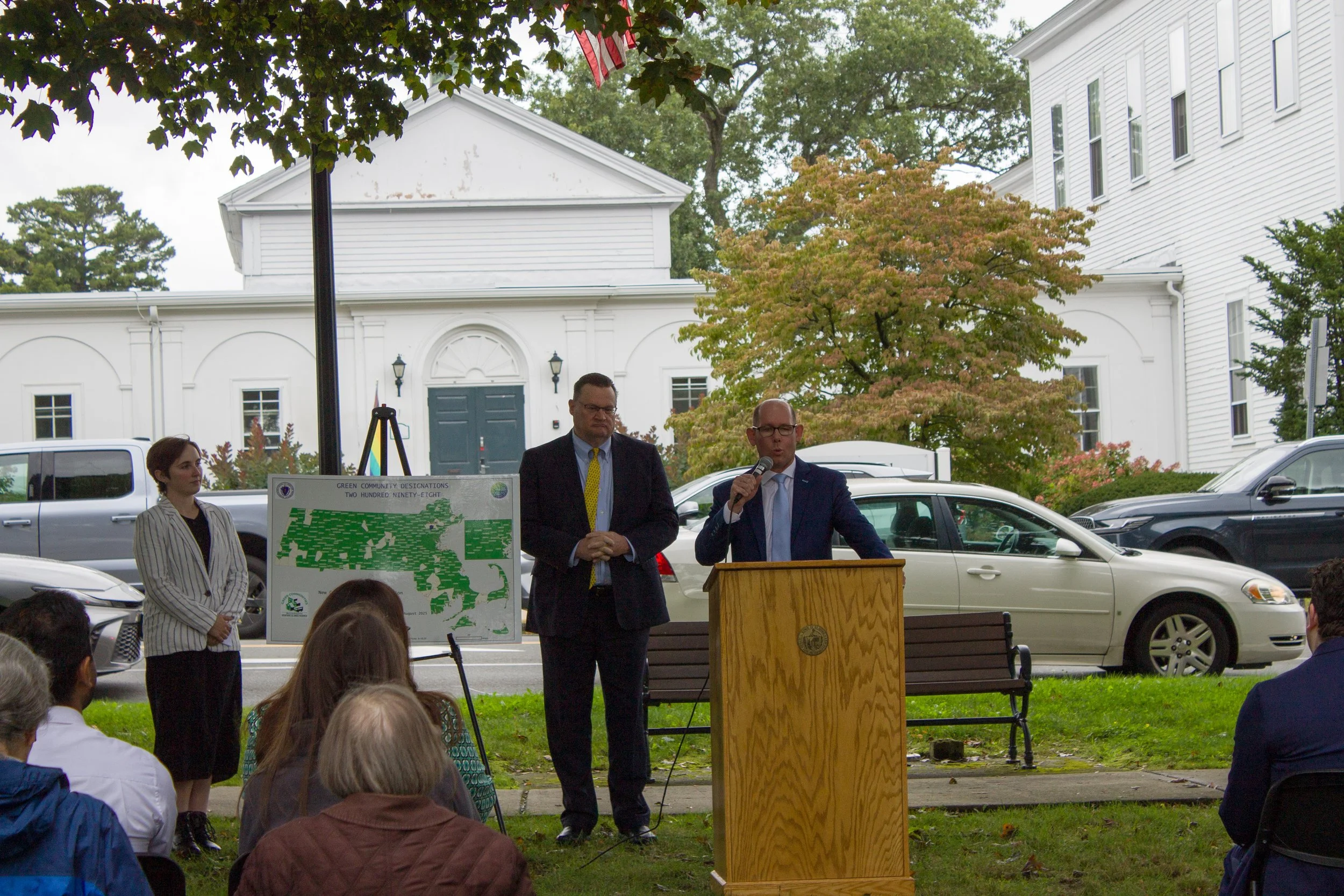 Rep. Haggerty addressing the crowd with Rep. Brad Jones and a representative from Senator Jason Lewis's office at the Green Communities Designation Event on August 21, 2025.