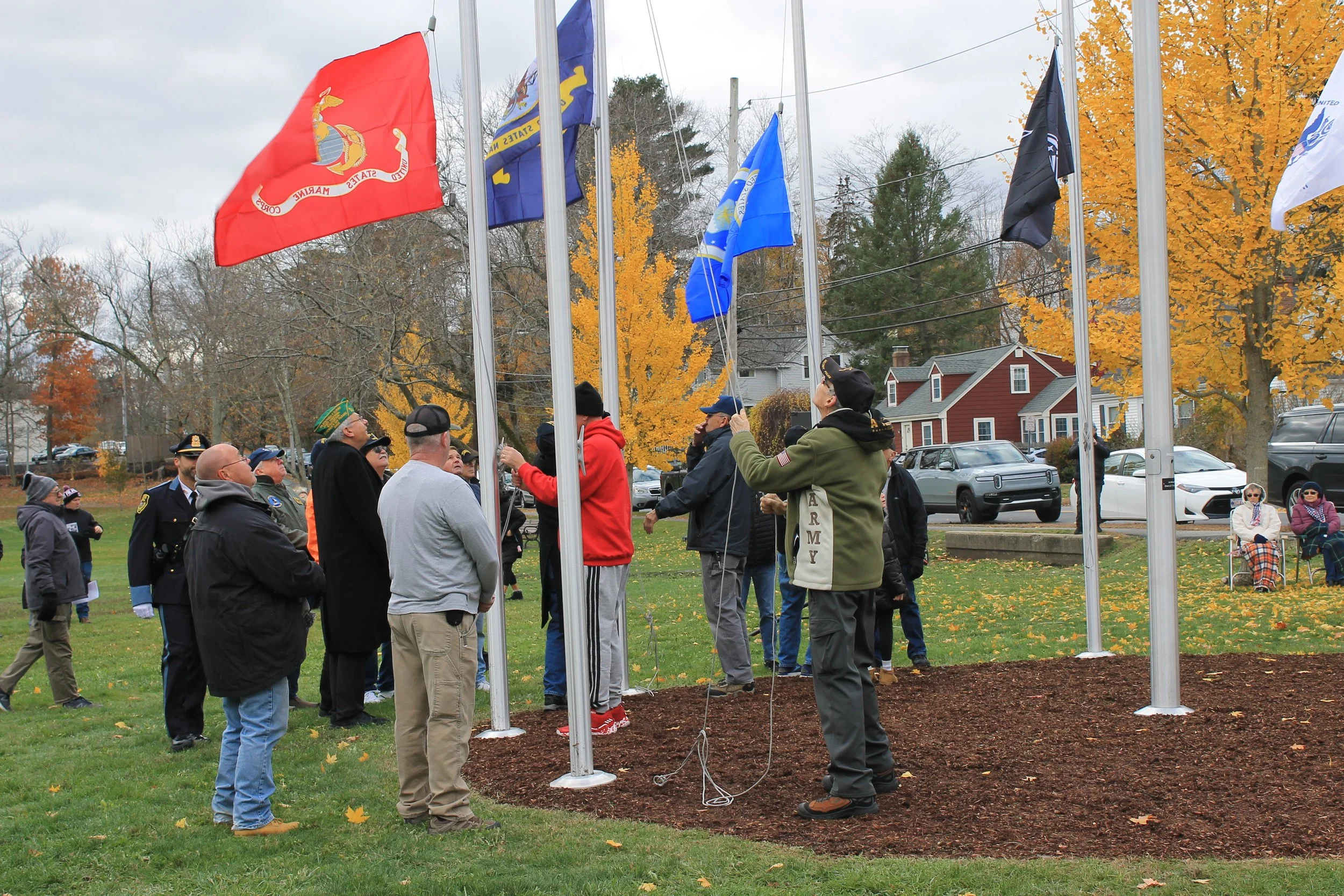 Members of various service branches raising their respective flags at the Veterans Day Ceremony at Memorial Park.