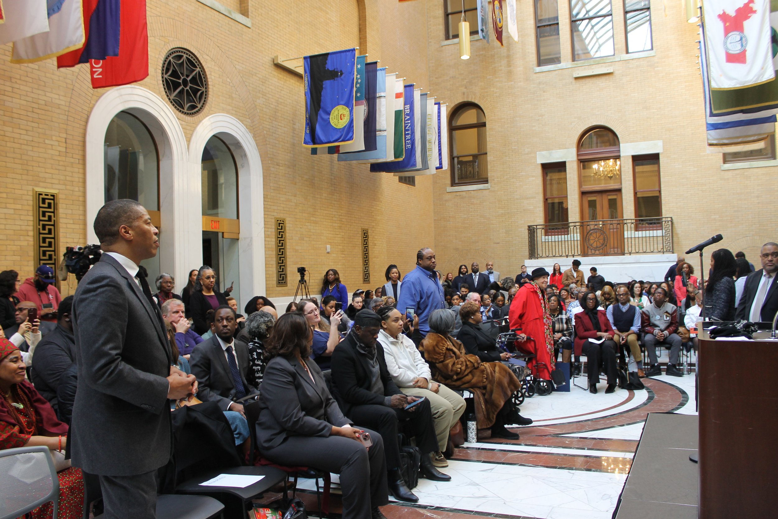 Community members, officials, and honorees hill the Great Hall of Flags for the ceremony recognizing Black excellence across Massachusetts.