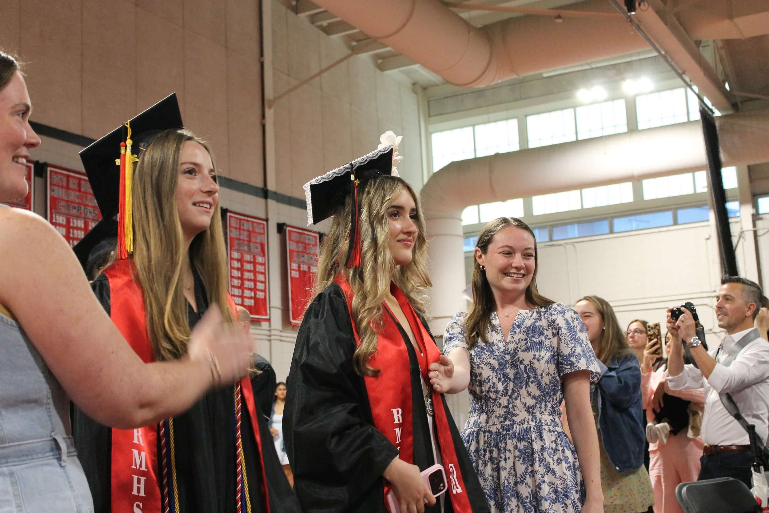 Members of the Class of 2026 smile as they process into the Fieldhouse to begin the graduation ceremony, greeted by cheers from the packed stairs.