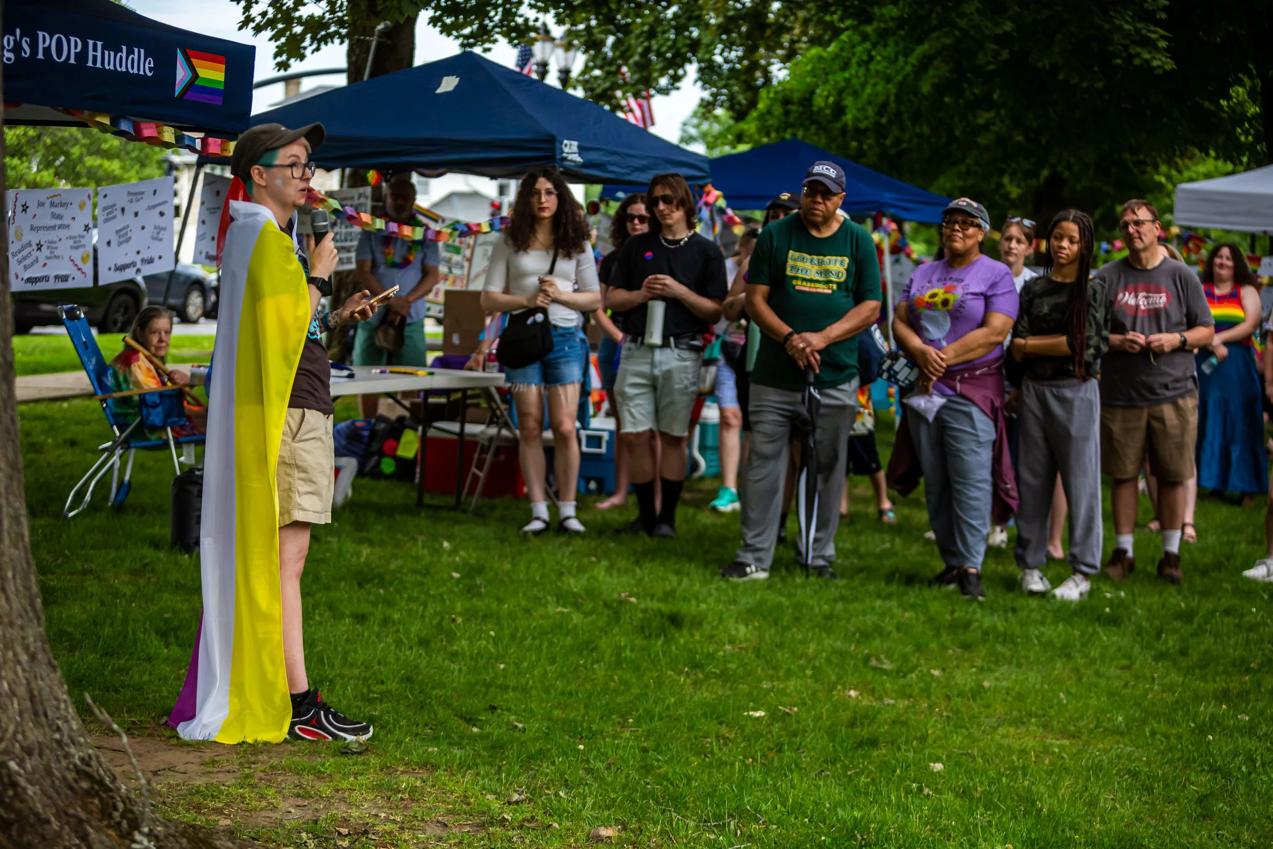 Taylor Gregory, draped in a non-binary pride flag, addresses the crowd gathered on the Common, delivering a speech on why representation matters.