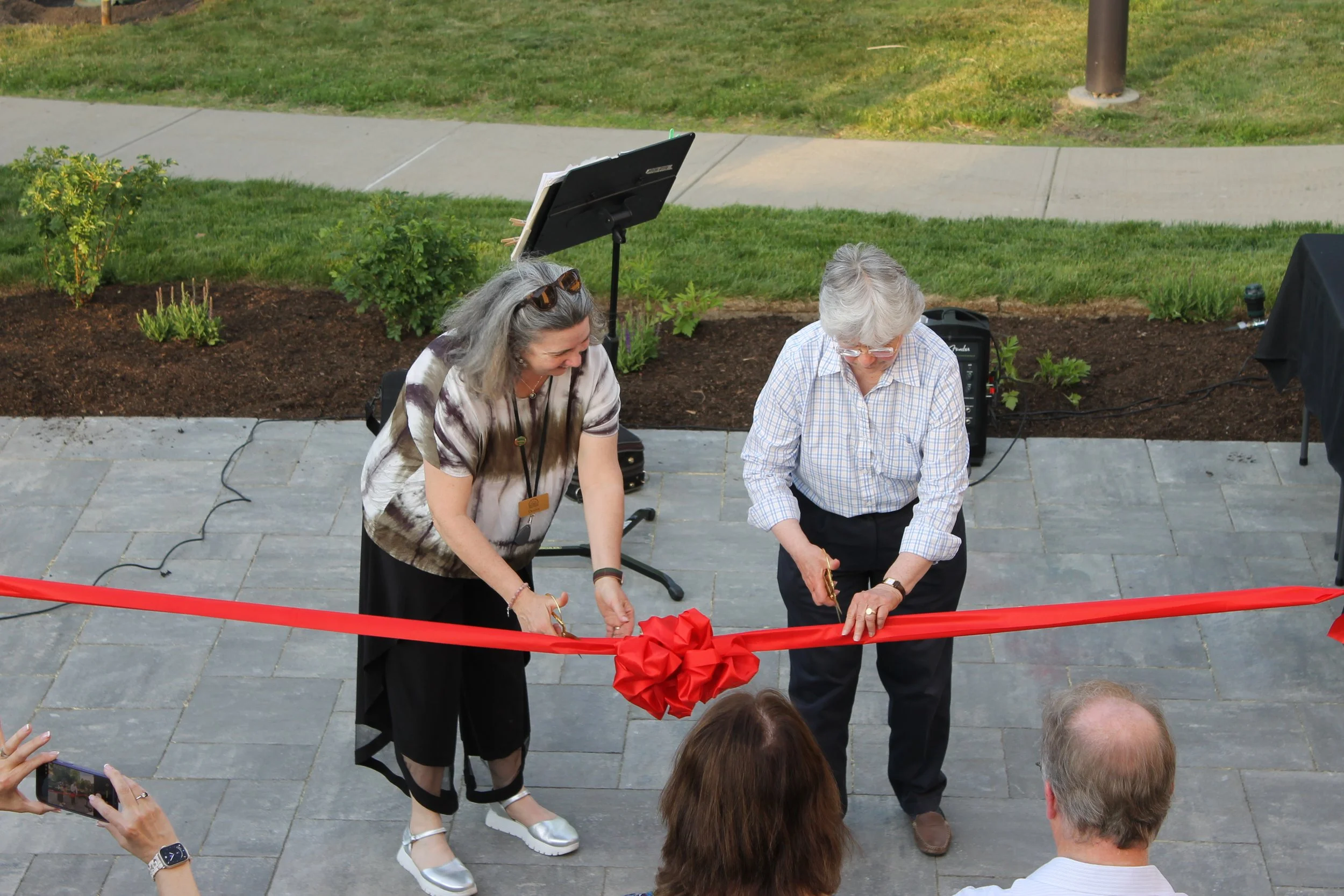 Desirée Zicko and Cherrie Dubois cut the ceremonial ribbon  on the stone patio of the new RPL Terrace on June 4, 2026, officially opening the outdoor space to the Reading community.