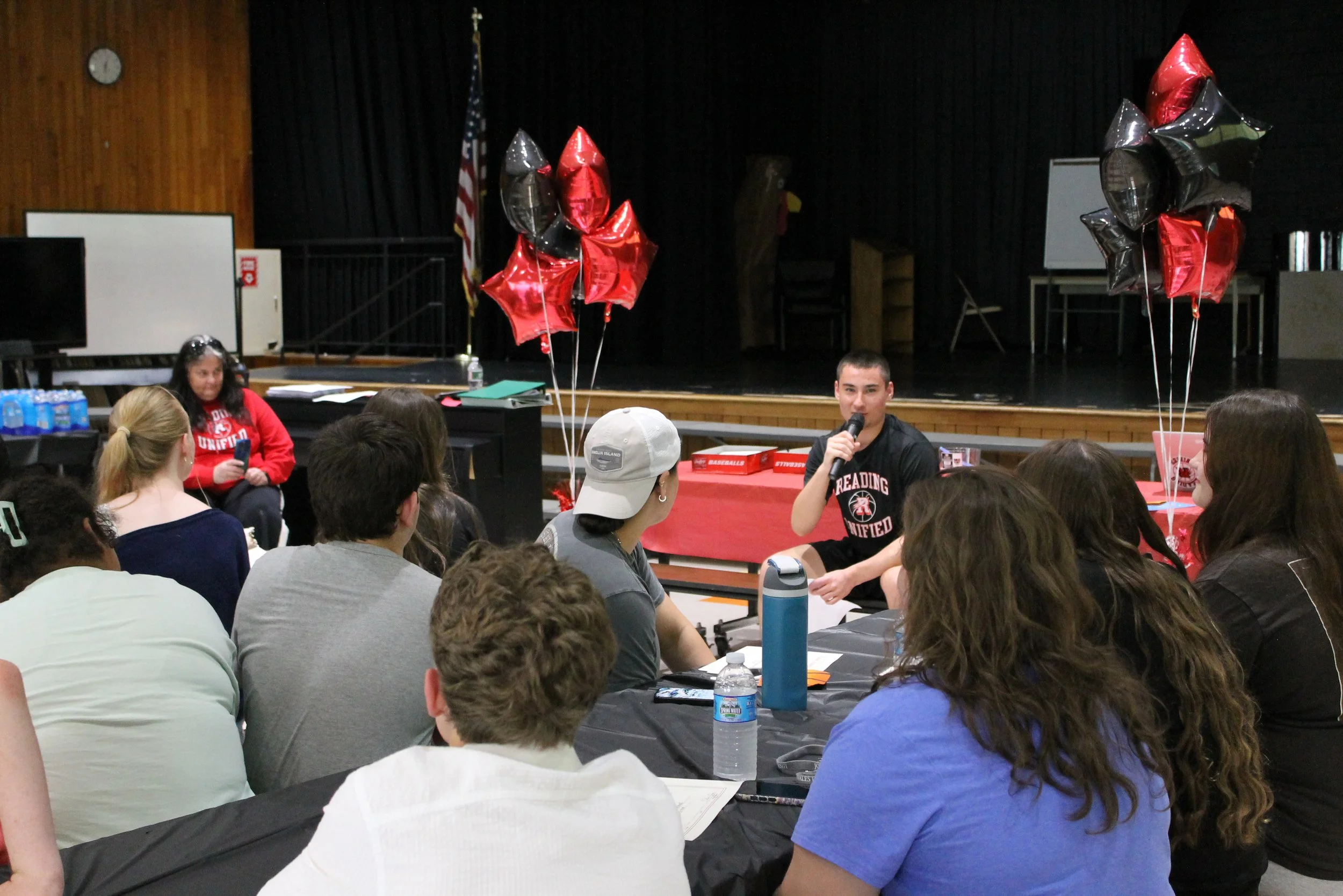 Jack Powers speaks into the microphone, sharing why he should be captain in the upcoming year.