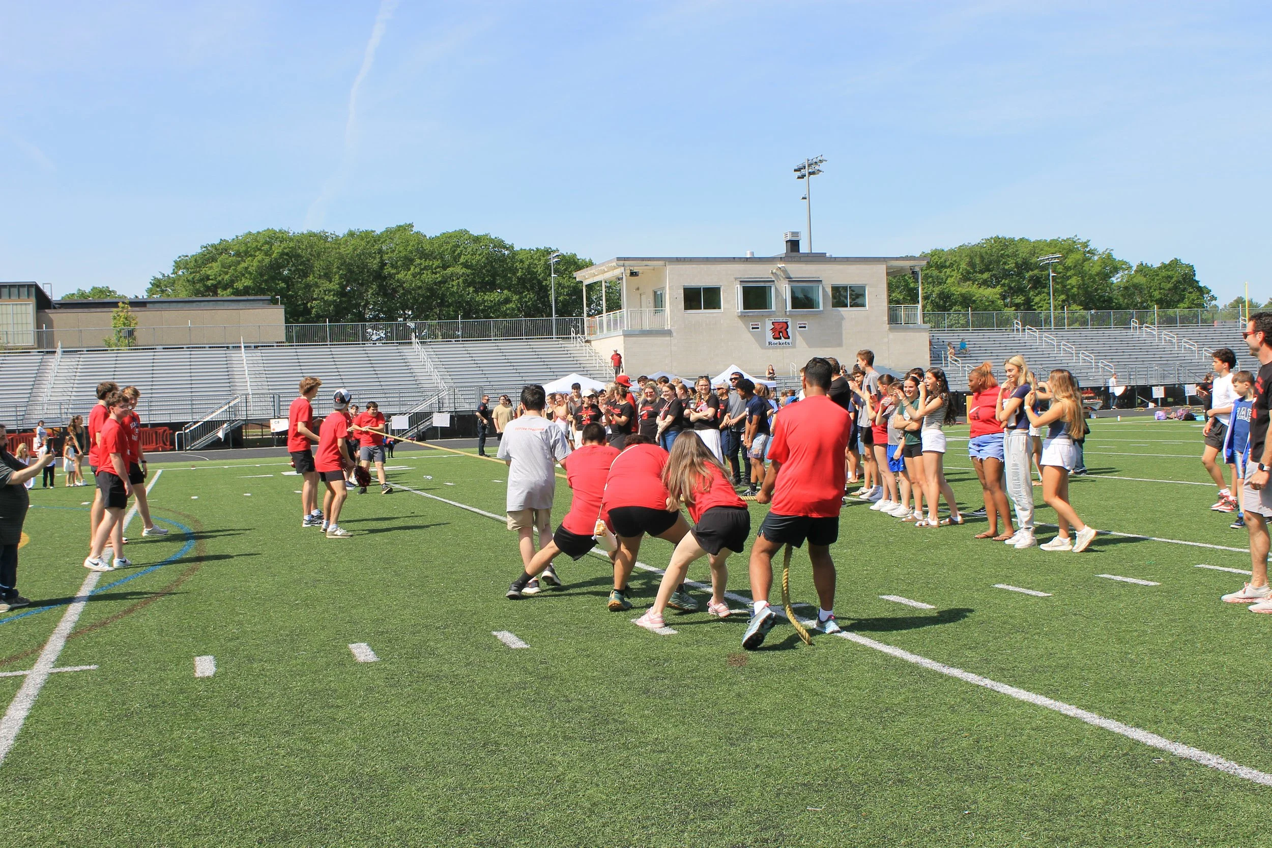 Teams compete in a rope pull as classmates cheer from the sidelines.