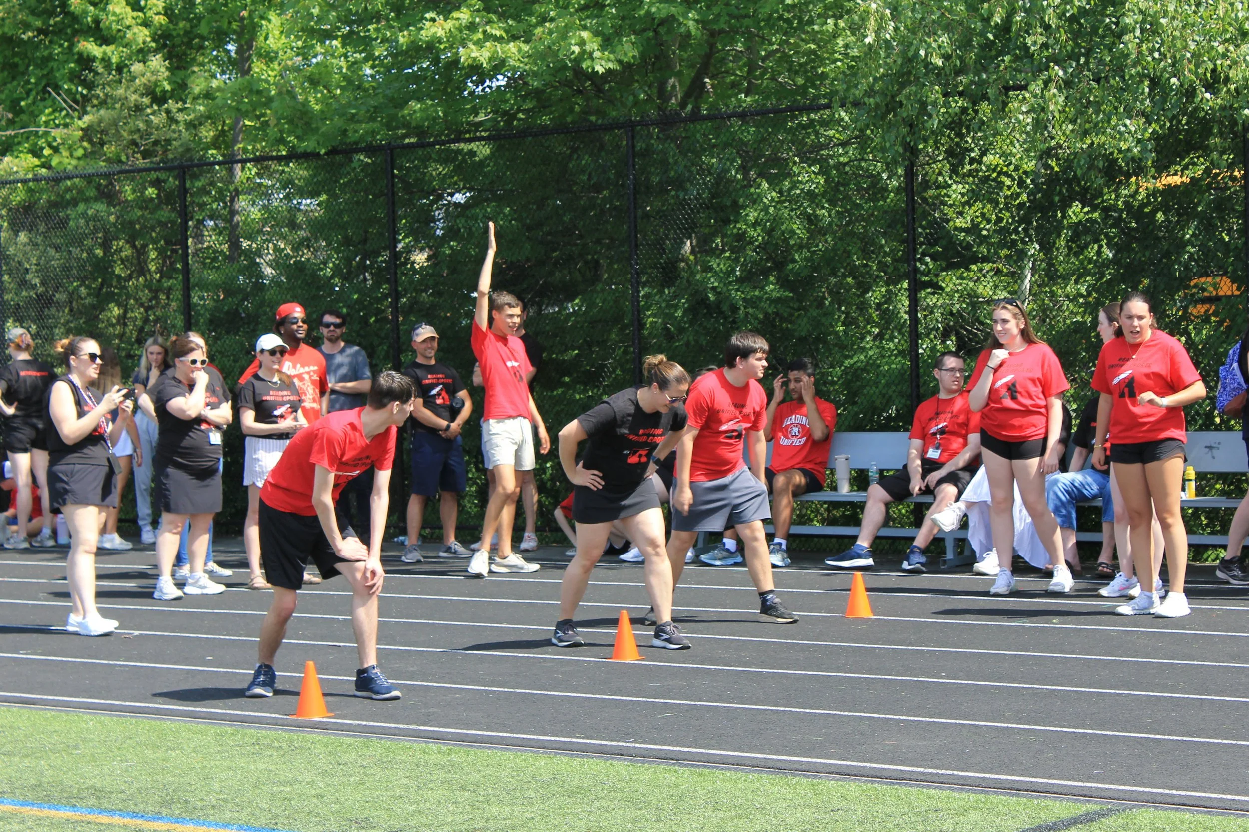 Athletes line up in the starting position, ready to sprint as classmates cheer them on from the sidelines.