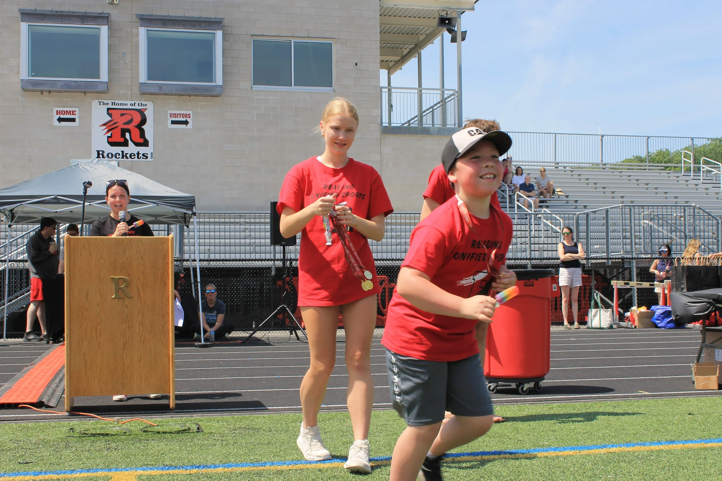Student volunteers carry medals across the turf as the day's events come to a close.