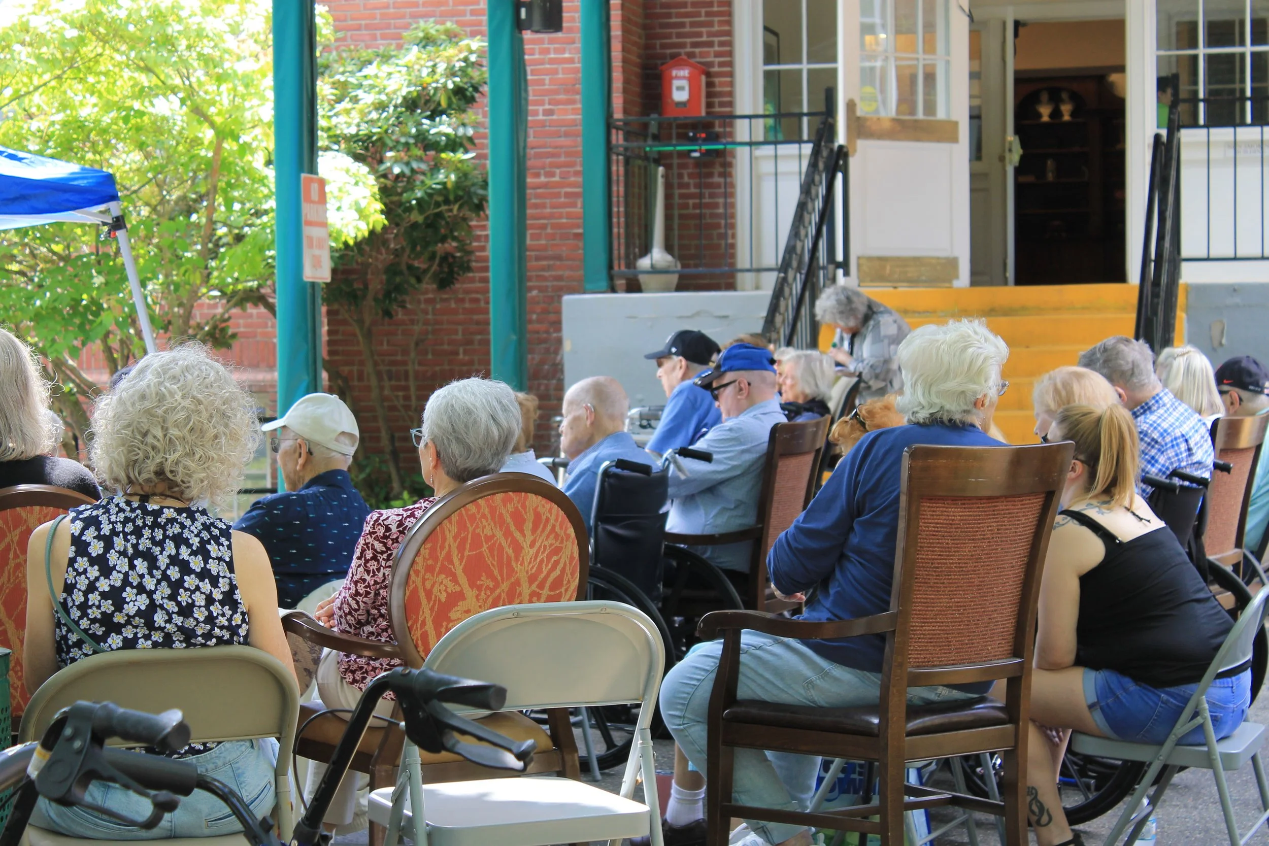 Seniors and visitors gather outside The Residence at Pearl Street for Porchfest performances.