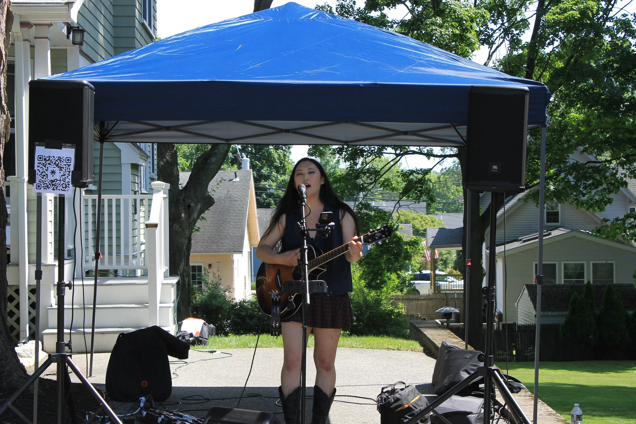 Jasmine Im performs at 91 Pleasant Streeet under a blue tent.