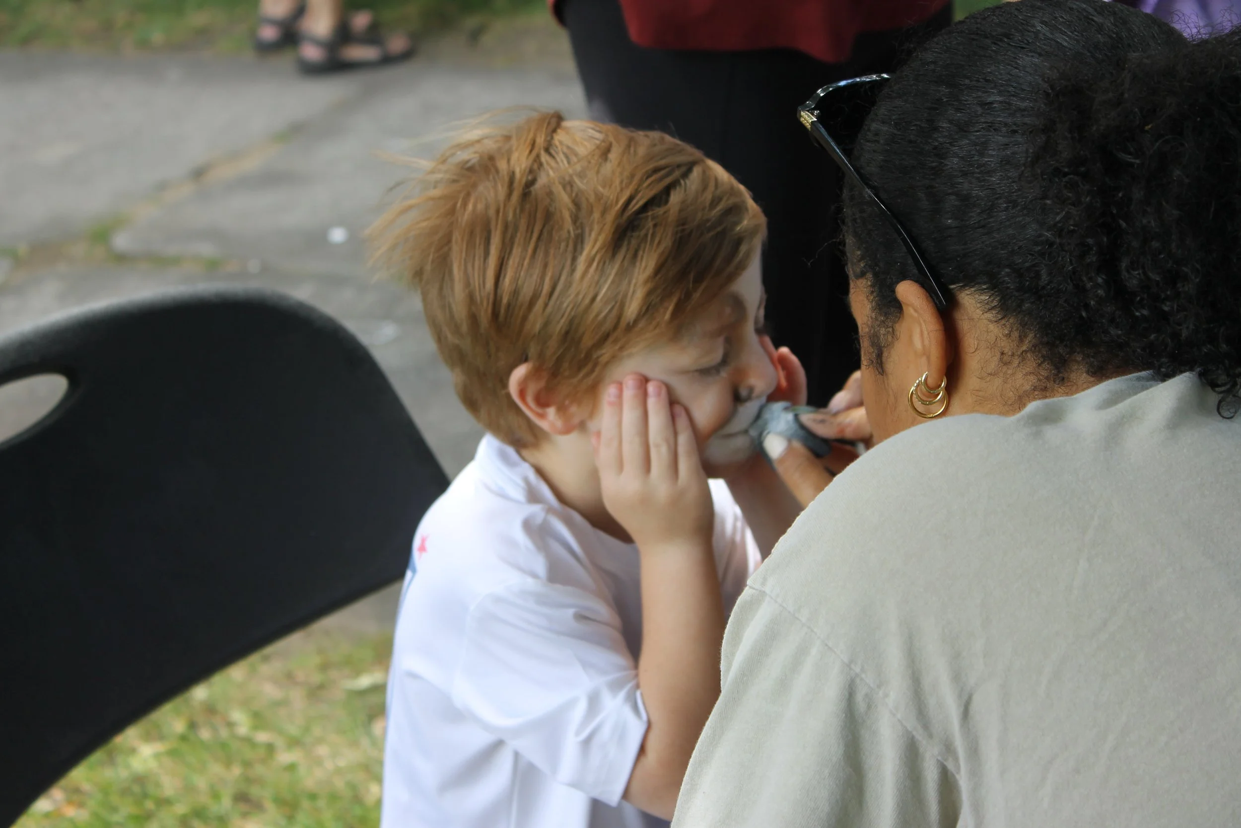 A young attendee holds still for a face painter, one of the family-friendly activities on offer.
