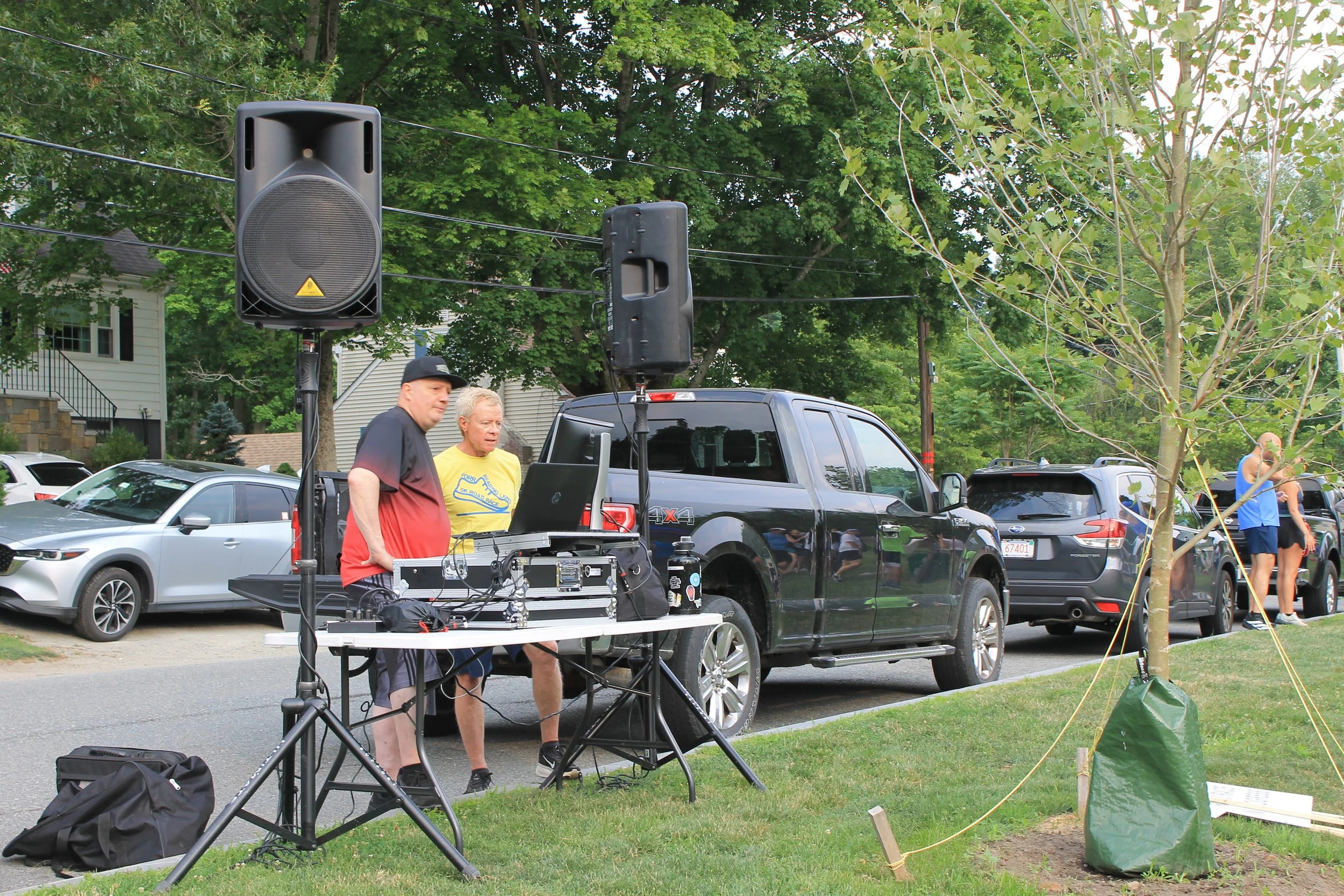 A DJ keeps the pre-race energy up from a setup along the course, one of the volunteer crews that kept the evening running.