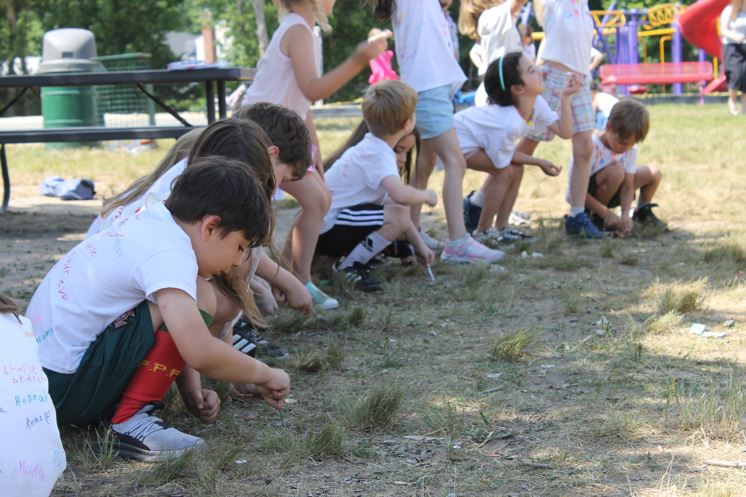 Killam students dig small scoops of dirt during the outdoor groundbreaking ceremony.