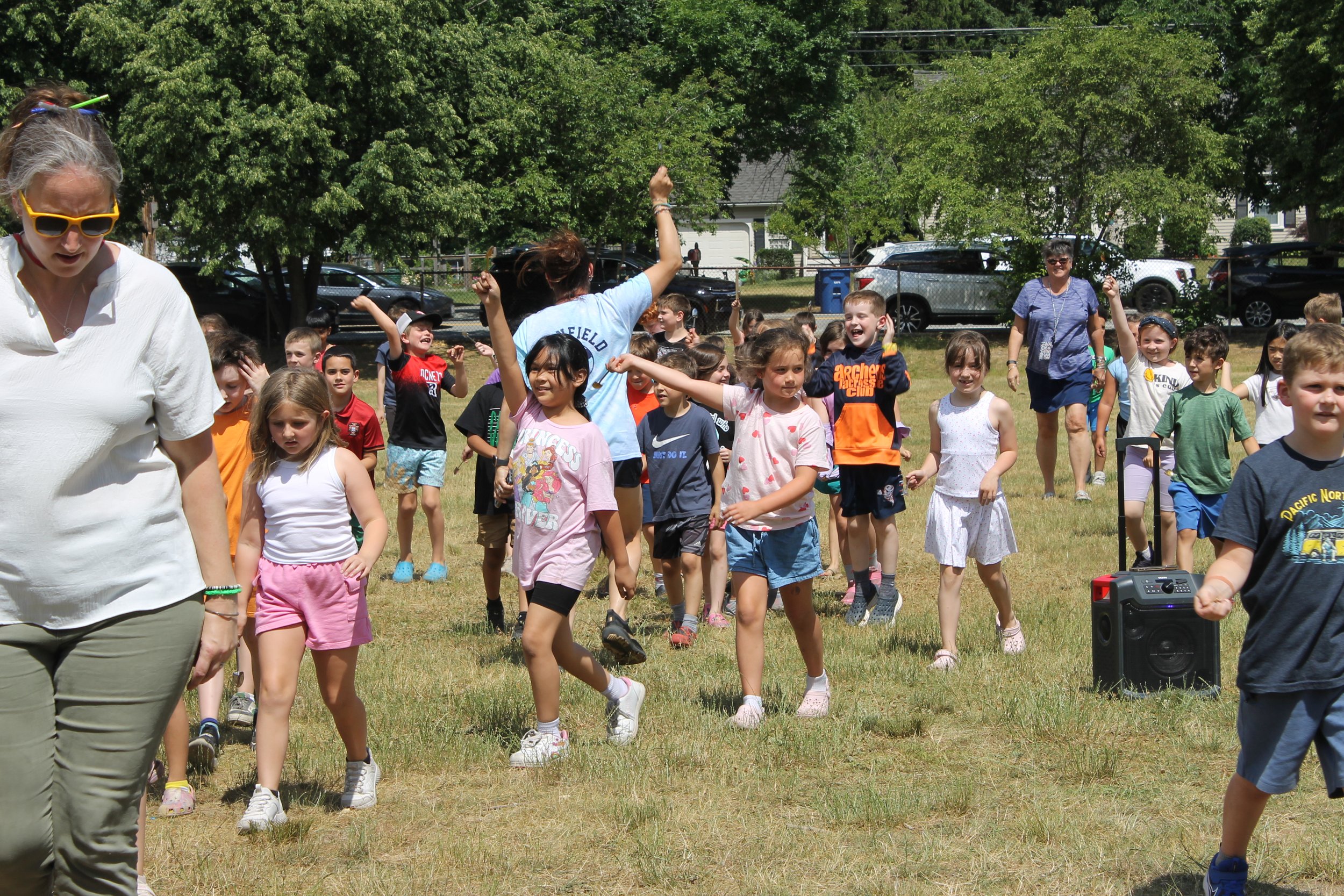 Students celebrate with raised arms during the June 17 groundbreaking event.