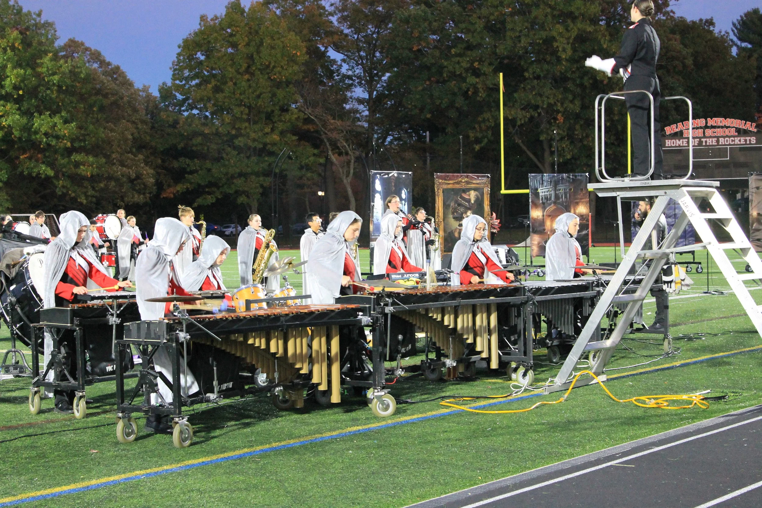 The front ensemble performs as the drum major conducts from above.