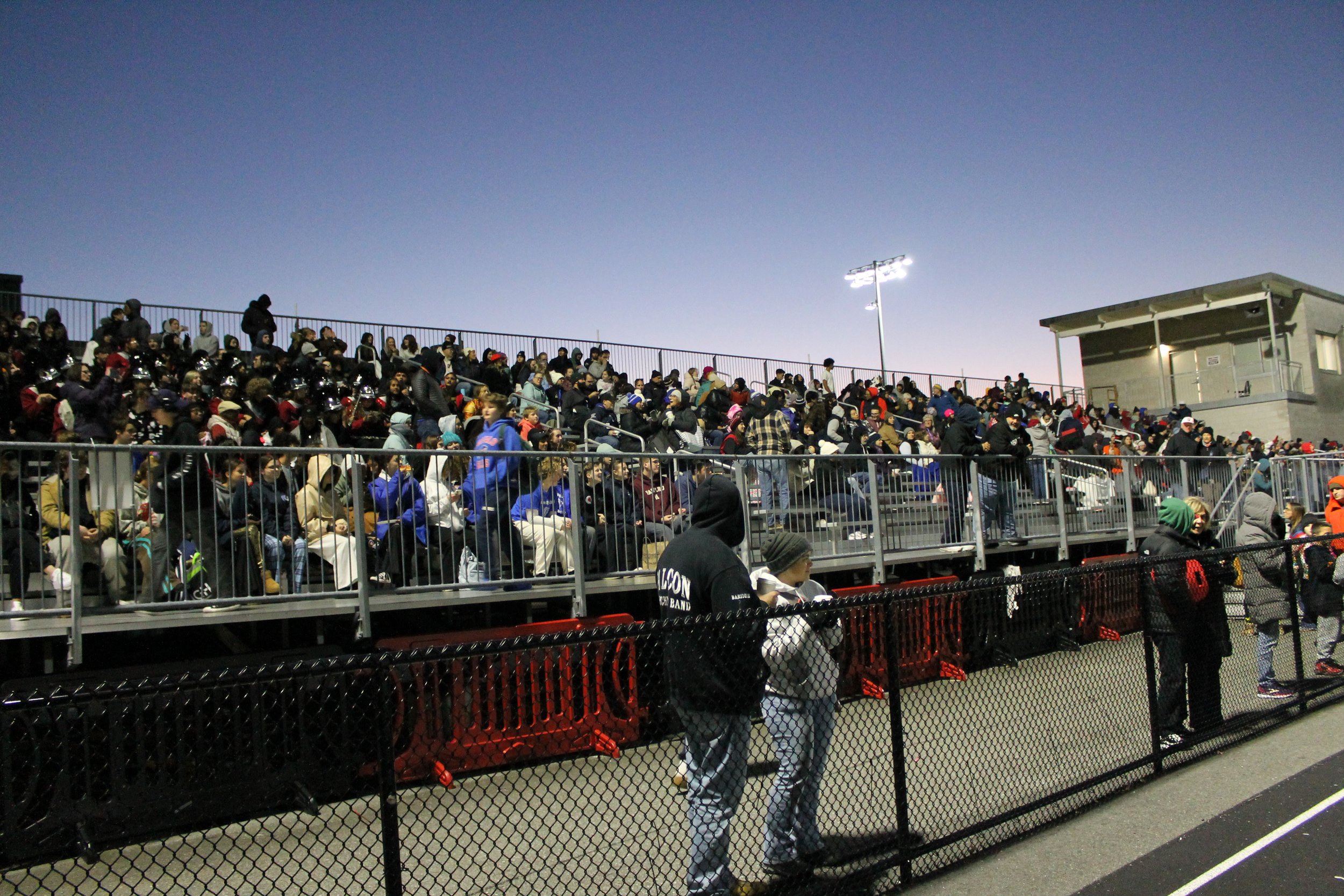 Spectators fill the stands at Hollingsworth Football Field as dusk falls over the competition.