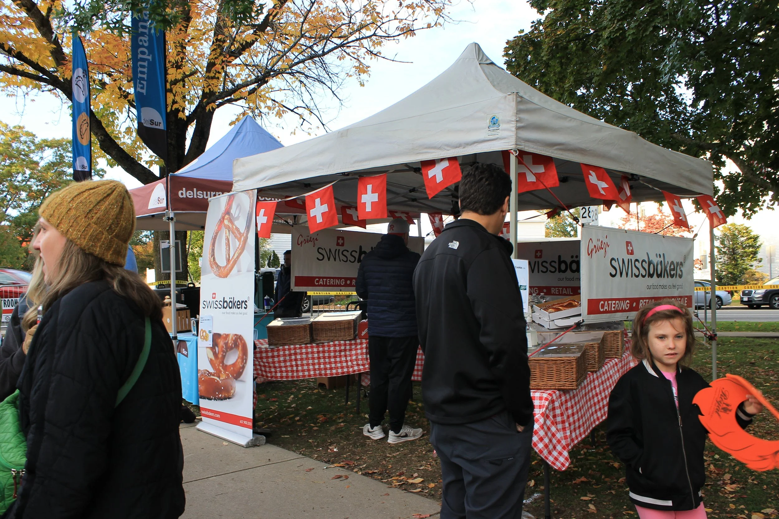 Swissbakers sets up under a tent decorated with Swiss flags, next to the Del Sur Empanadas tent.