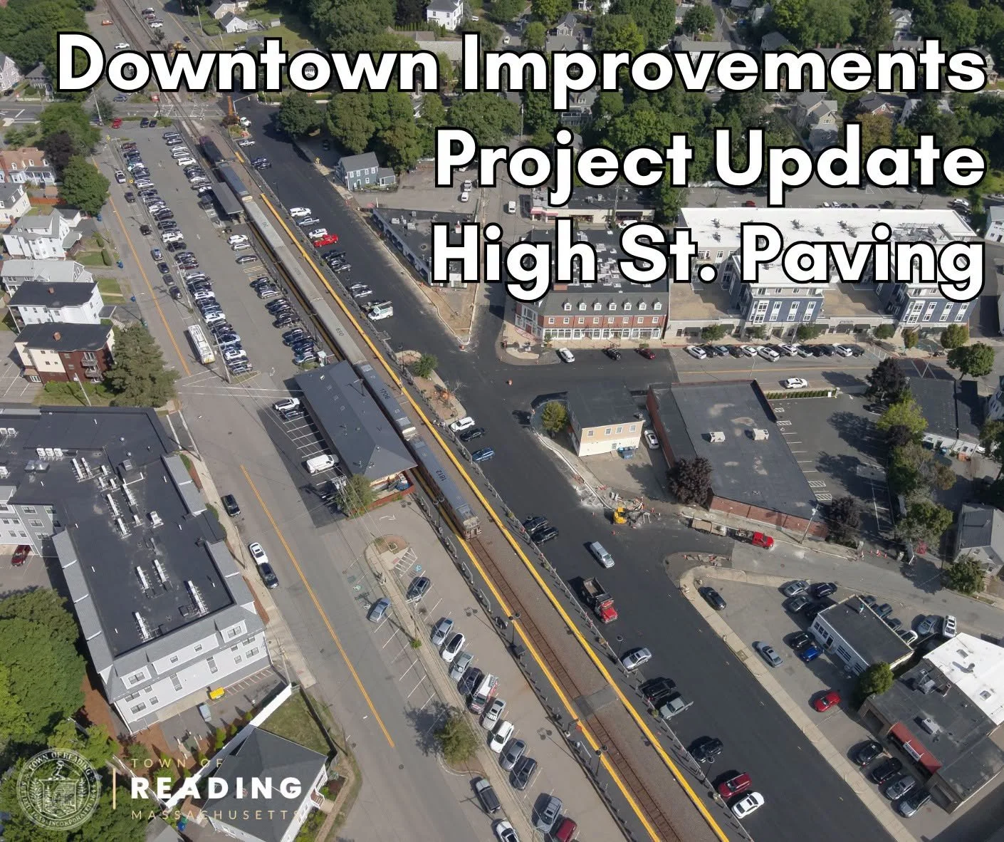 Aerial view of downtown Reading showing freshly paved High Street alongside the commuter rail tracks and parked cars, overlaid with the title "Downtown Improvements Project Update: High St. Paving."