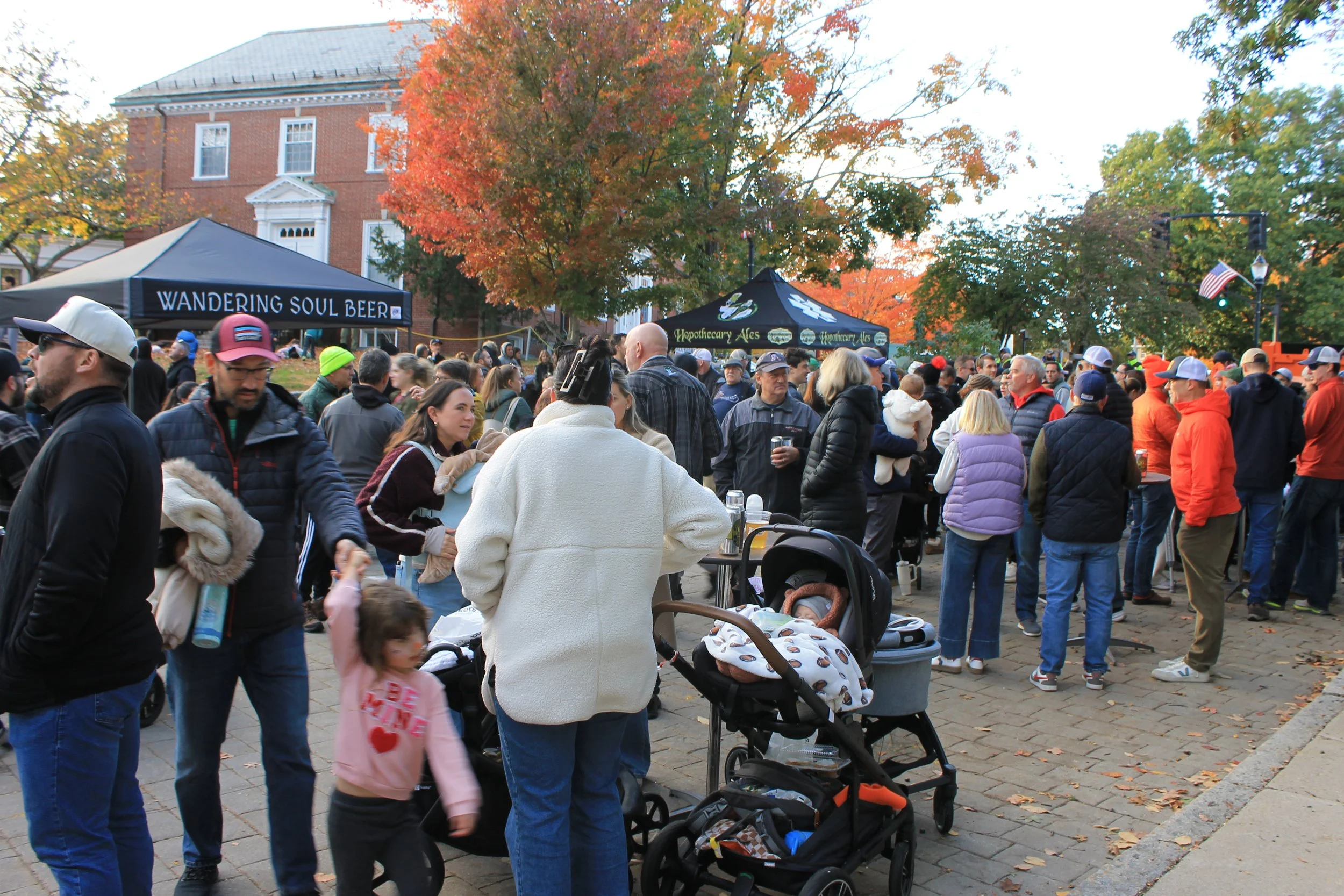Hundreds of residents gather on the Town Common on Saturday, Oct. 17, as brewery vendors serve under the fall foliage.