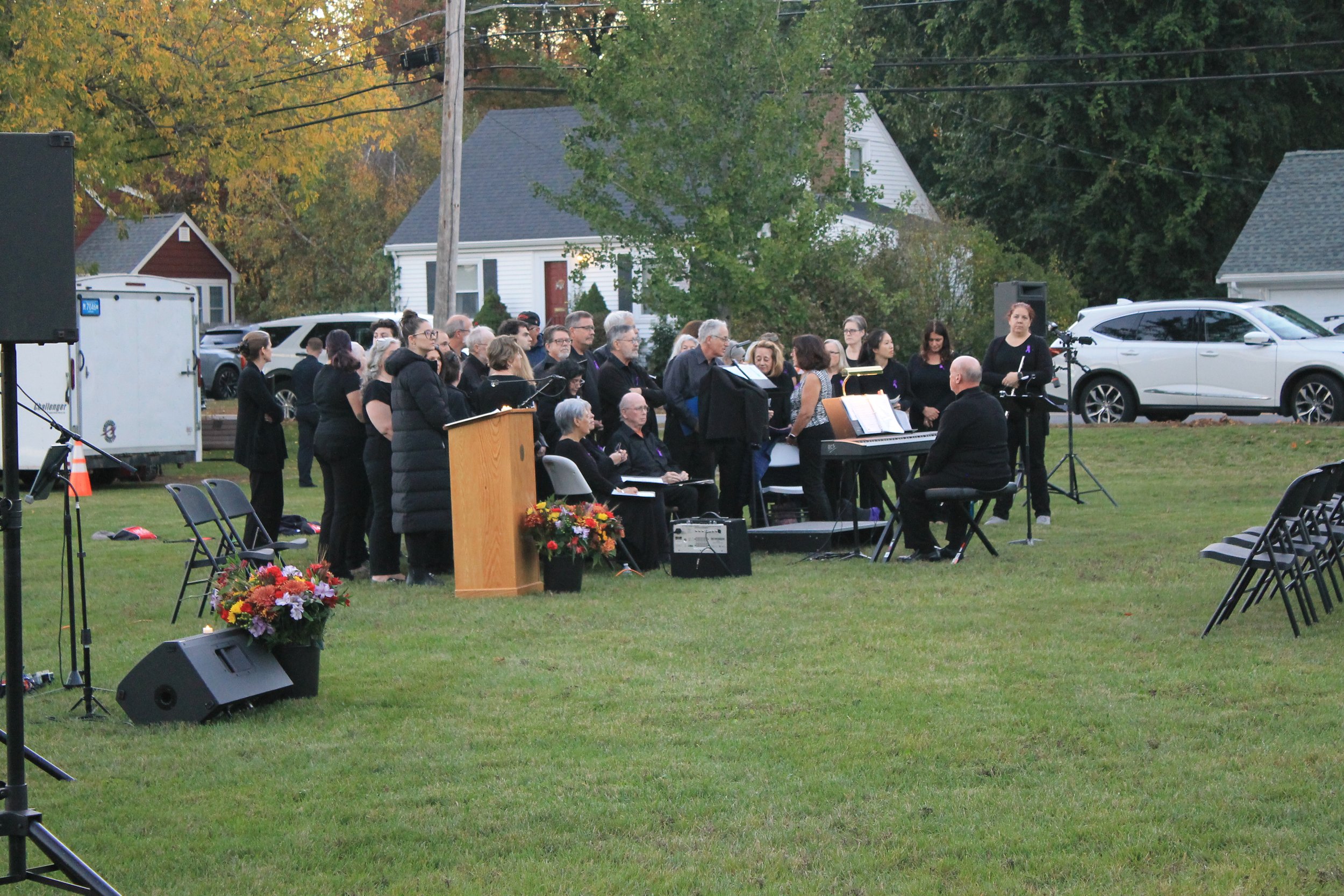 The Reading Community Singers, dressed in black, perform outdoors at dusk during the candlelight vigil for Andria Hanafin.
