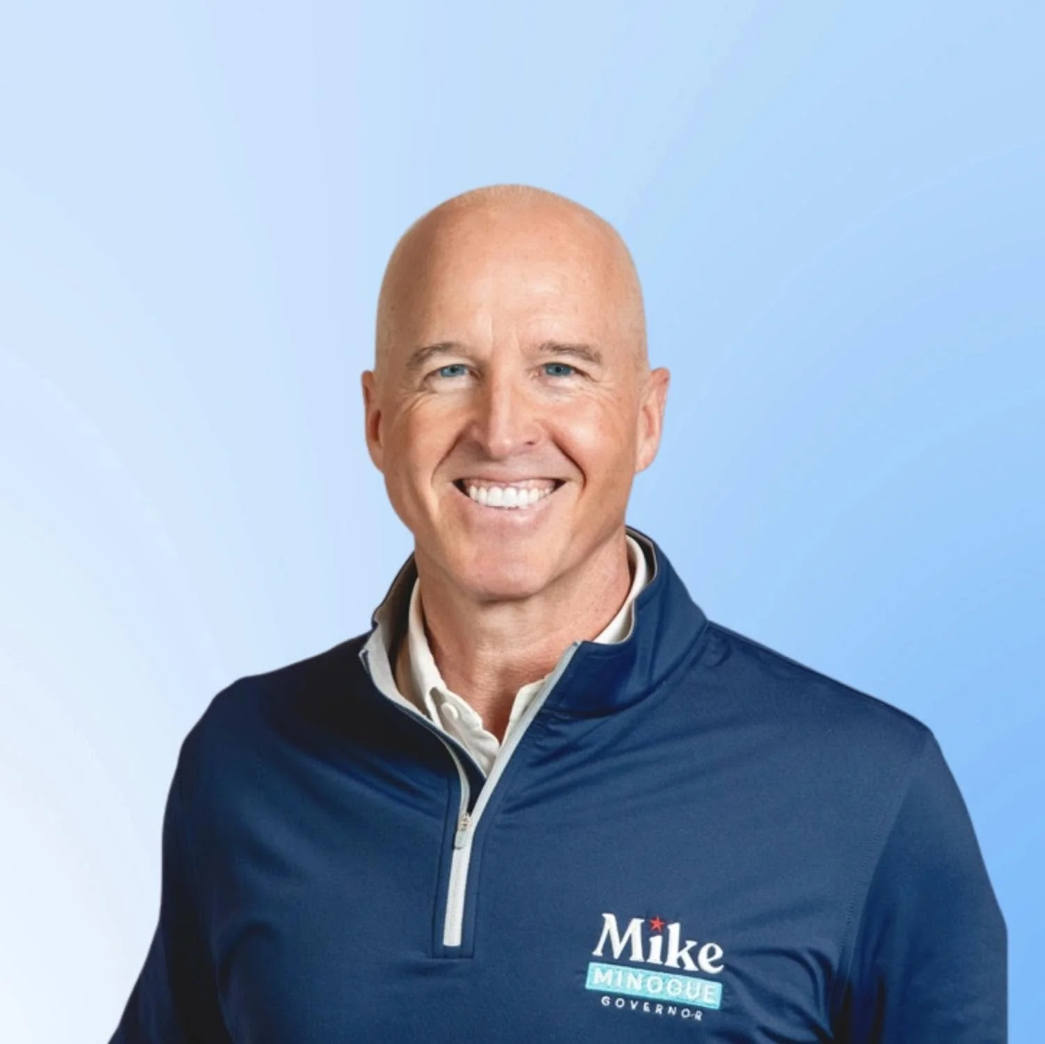 Portrait of Mike Minogue, a bald middle-aged white man in a navy quarter-zip with a "Mike Minogue Governor" campaign logo.