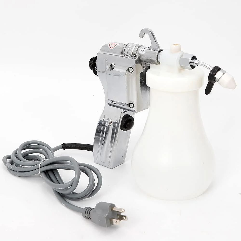 A spray gun with a metal body, attached to a white plastic container, and with a gray electrical cord coiled nearby.
