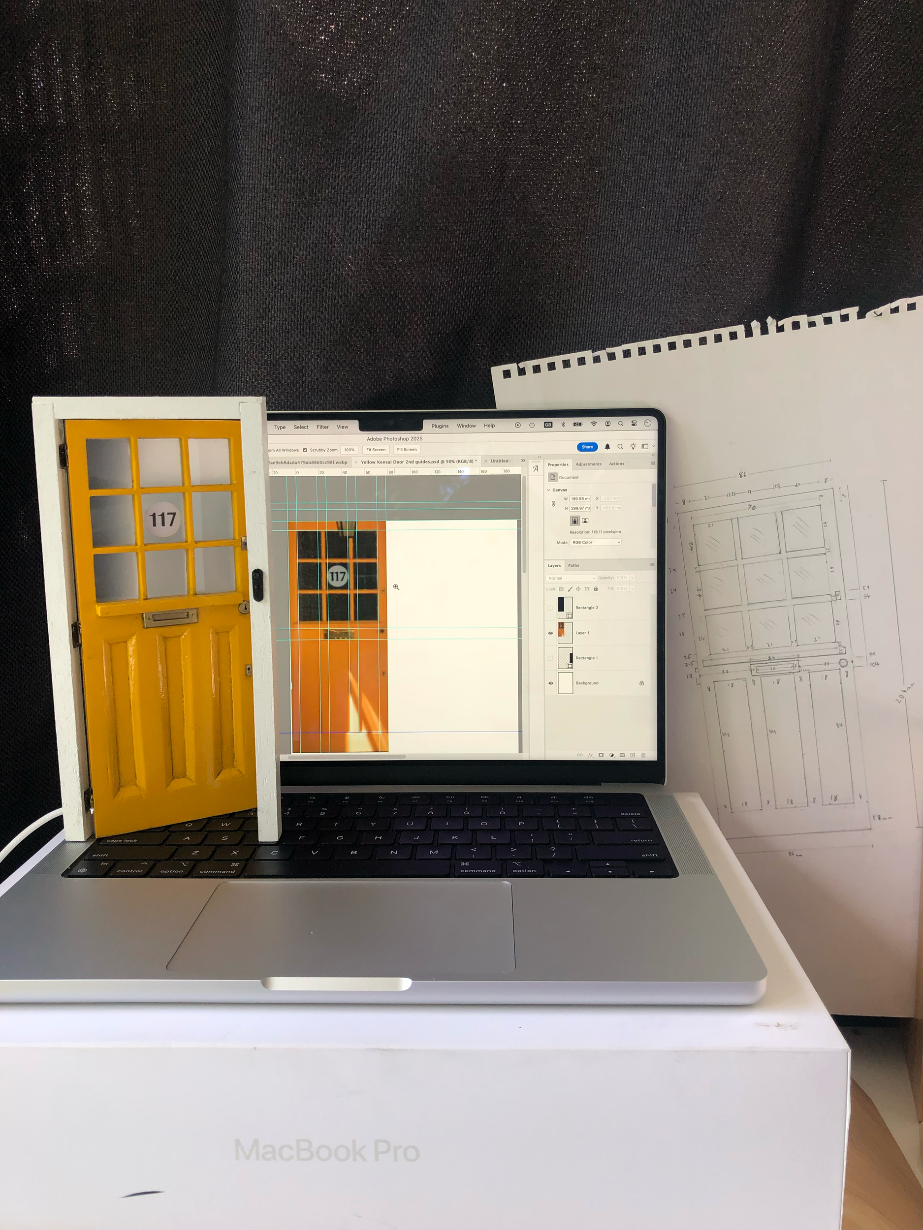 Final door and real world door photo alongside the paper technical drawing