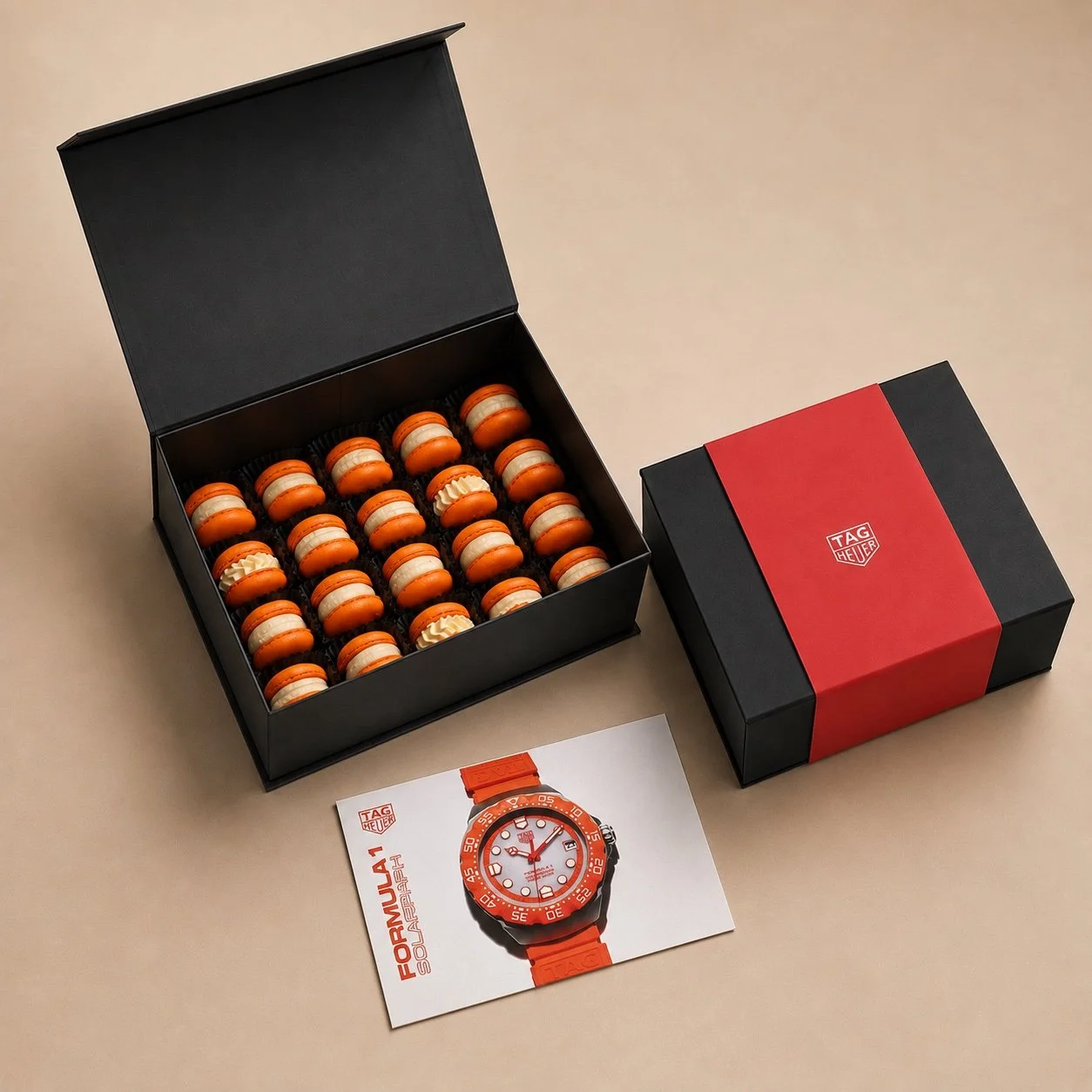 Black magnetic gift box with orange macarons and a red TAG Heuer sleeve