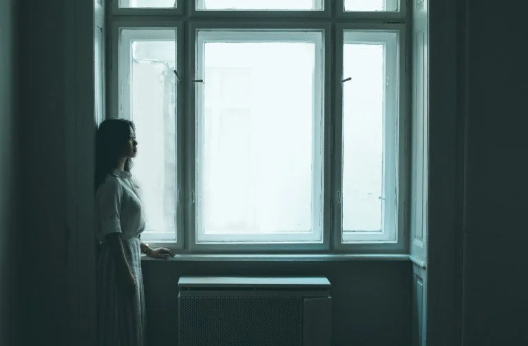 Woman near a window, mesmerized by things - Orthodox Therapist.jpg