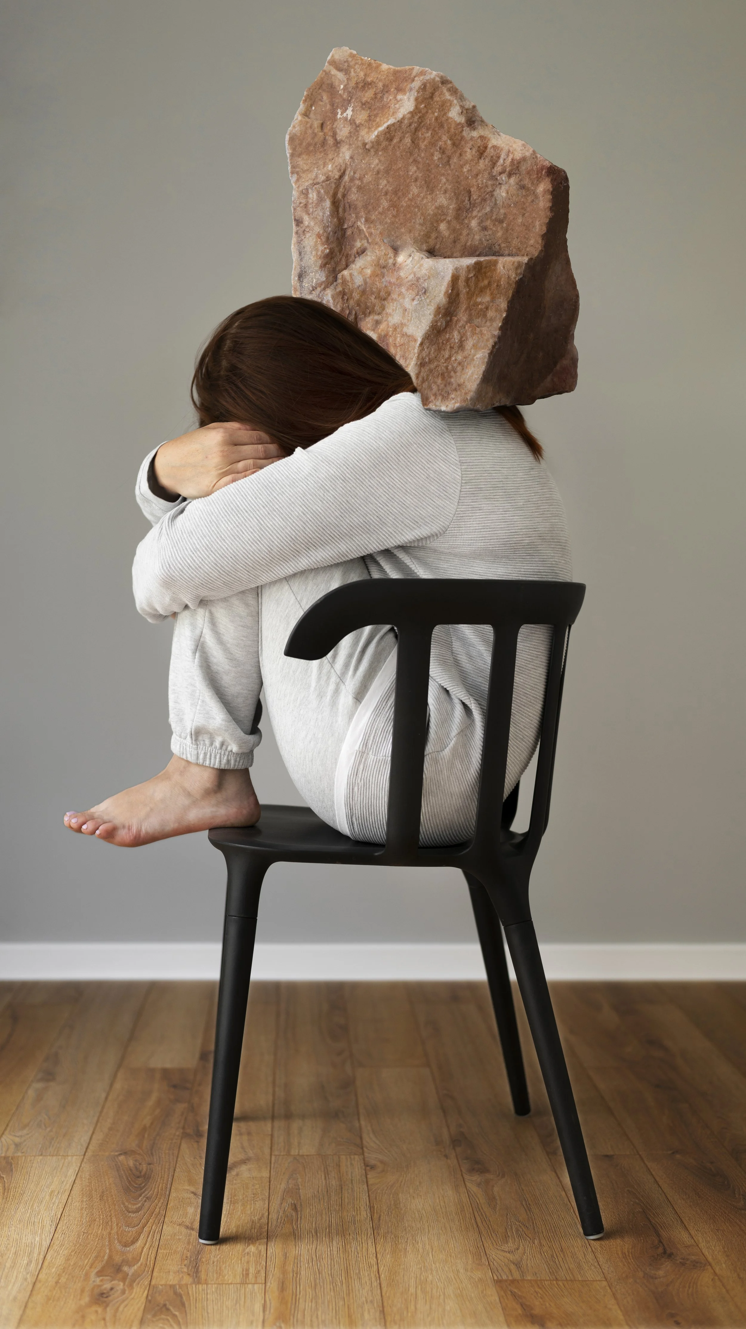 A woman sitting carrying a rock on the back -  The Orthodox Therapist