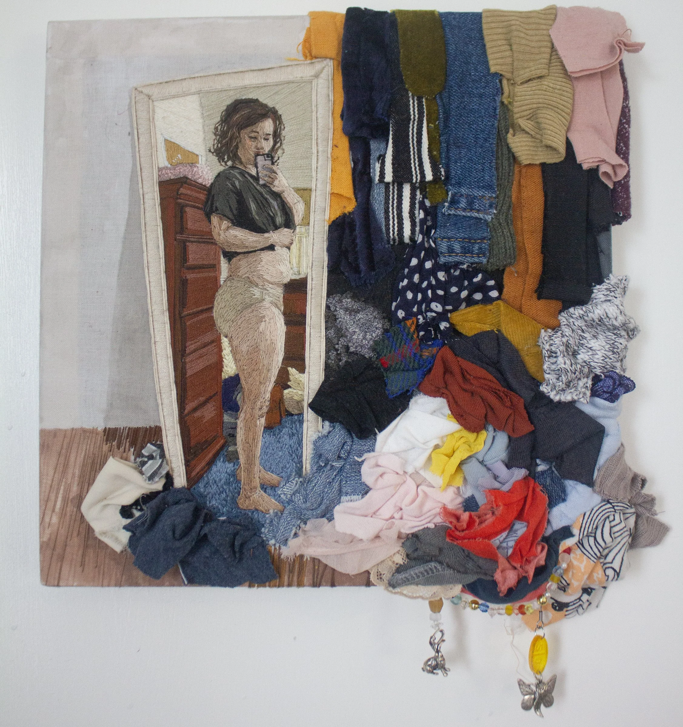  "None Of My Clothes Fit", 2026, 10"x 10" x 1", embroidery floss, cotton fabric, alcohol ink, scraps of the artist's used clothing, found objects, 