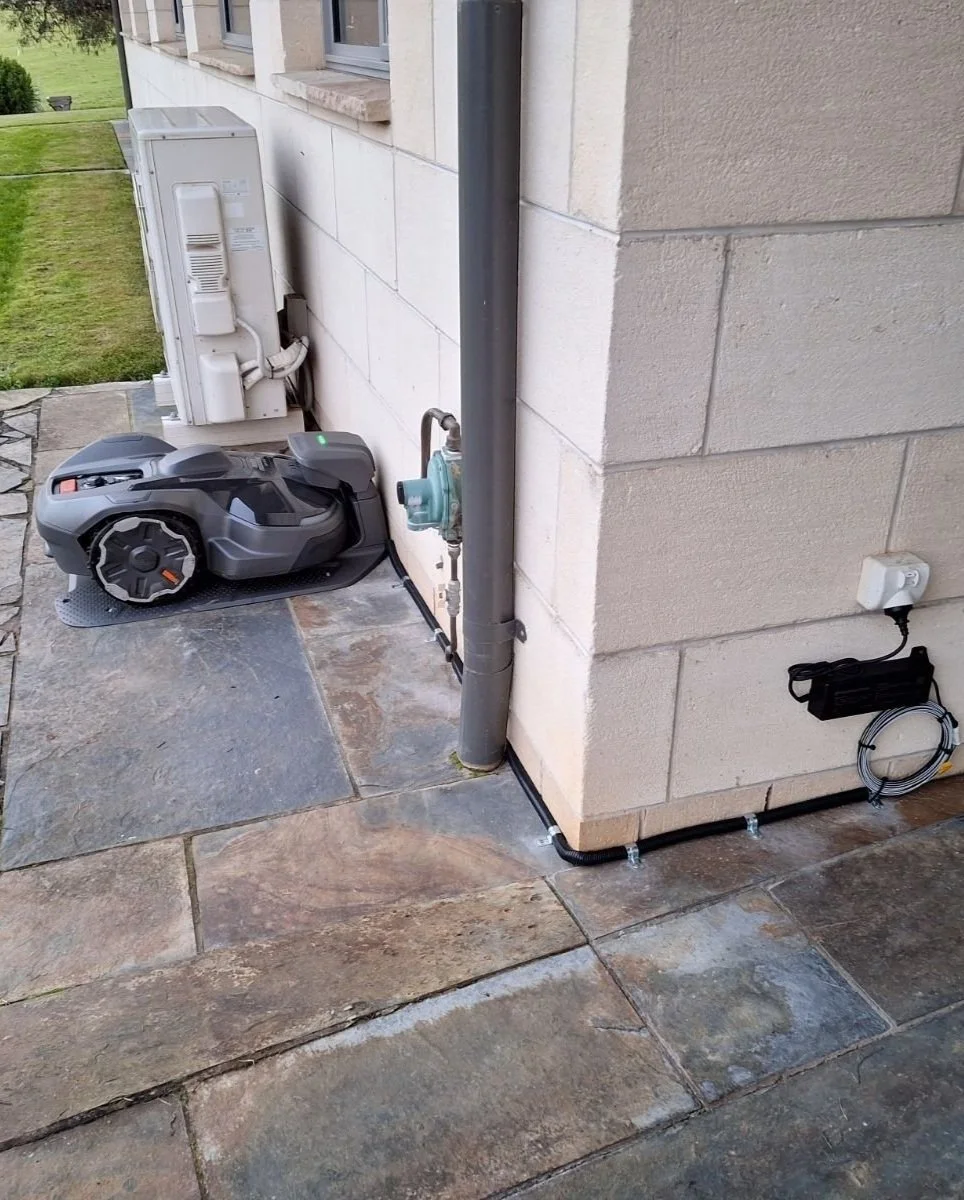 Husqvarna robotic mower boundary wire being installed around complex lawn layout