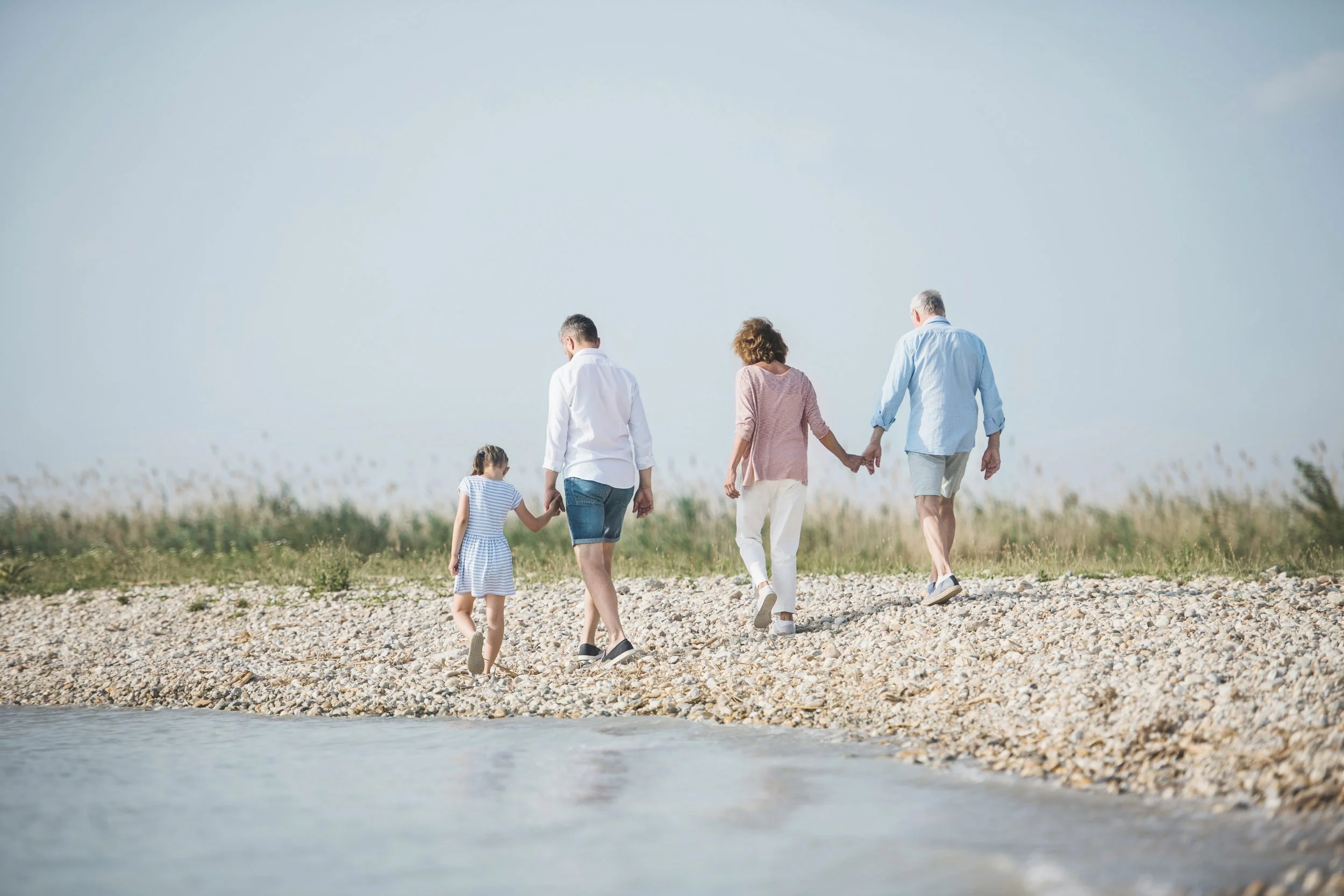 Multigeneration family walking on the beach