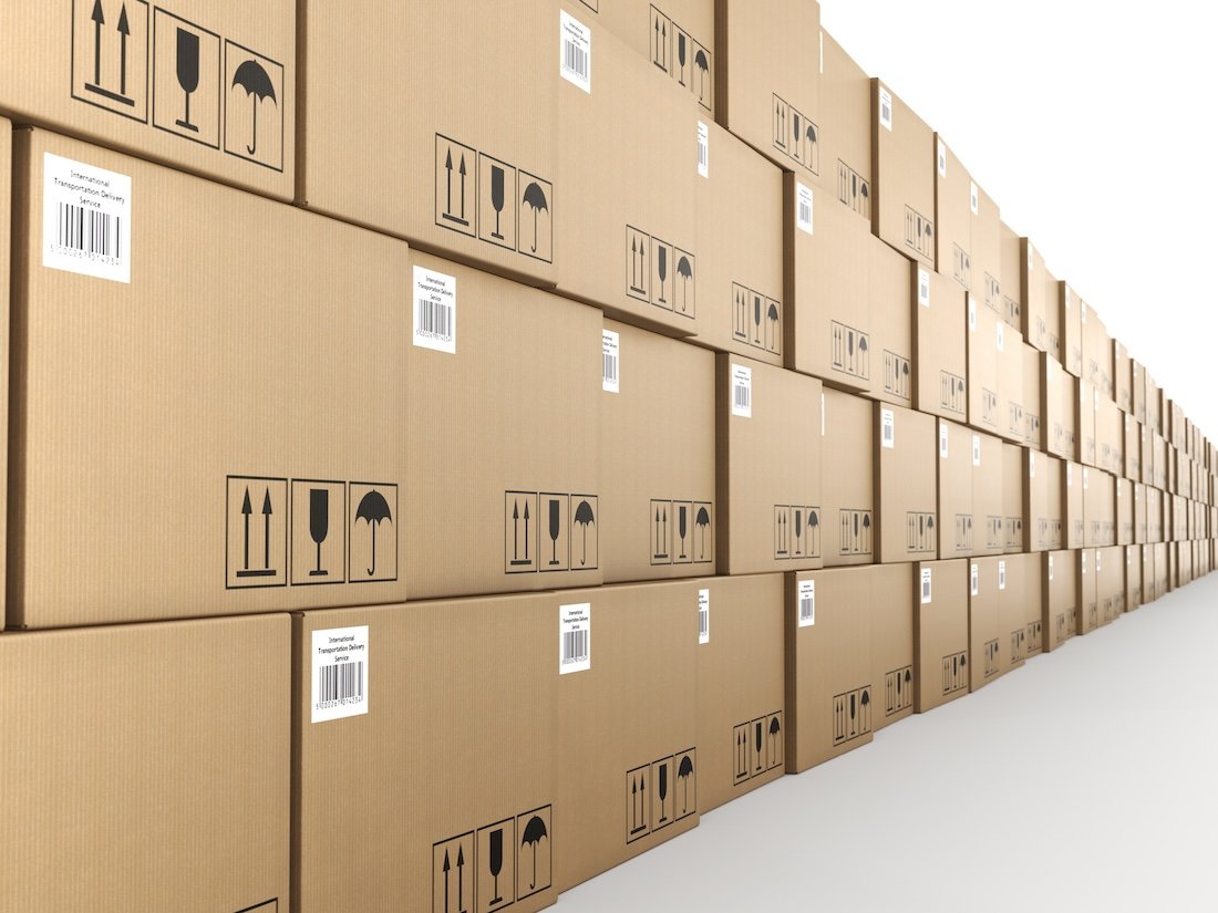 Stacked brown cardboard boxes with shipping symbols on the side, extending into the distance.