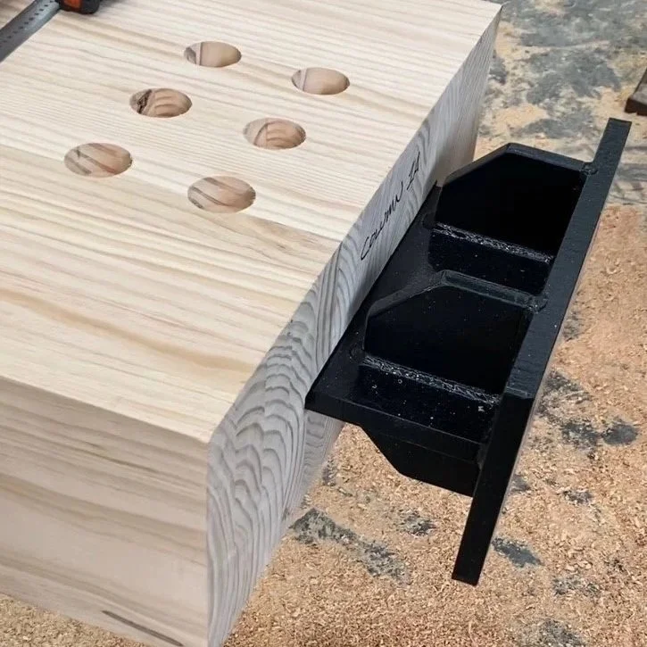 Glulam timber drilled holes next to a black fixture.
