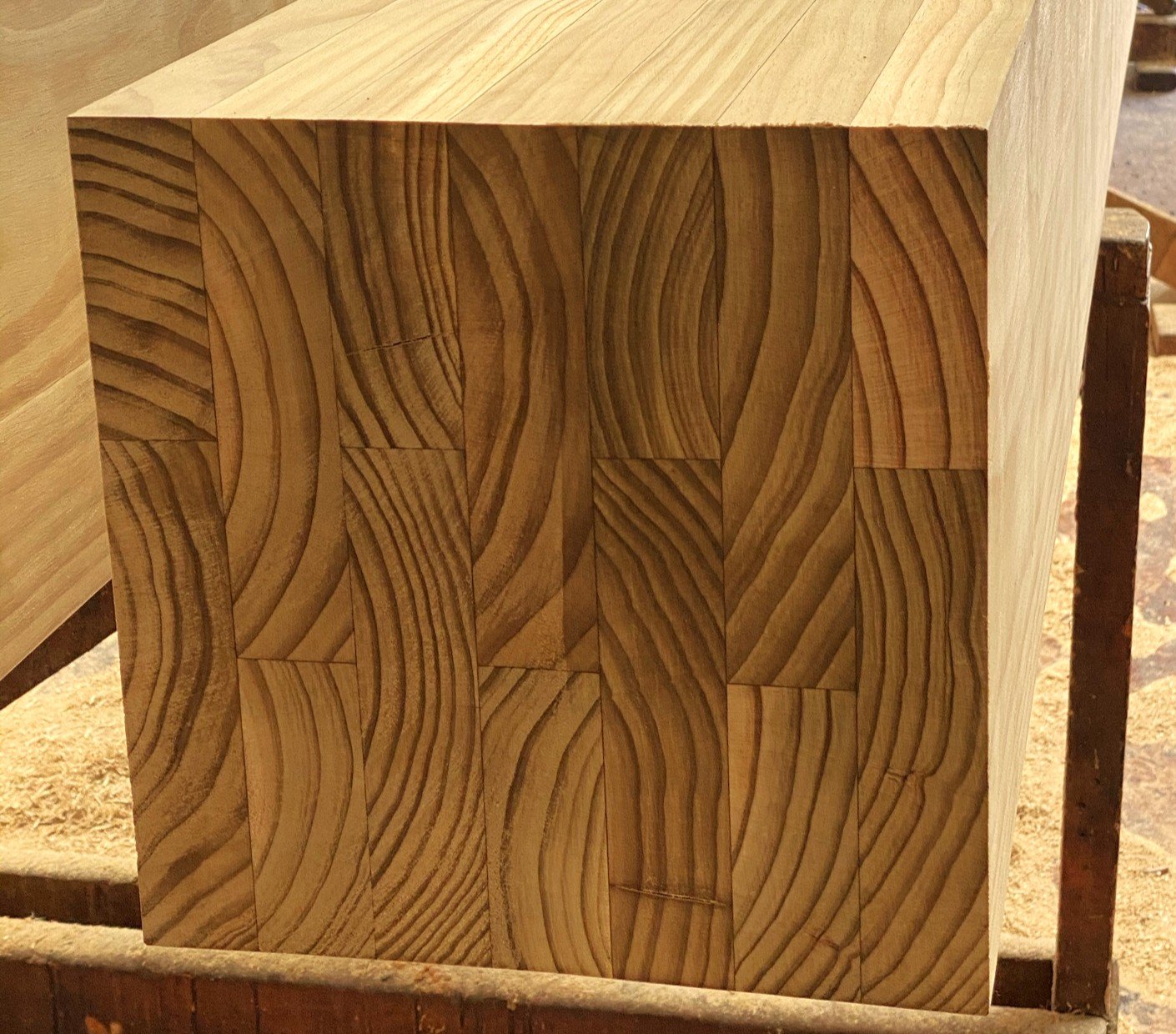 Glue laminated timber block with curved grain patterns.