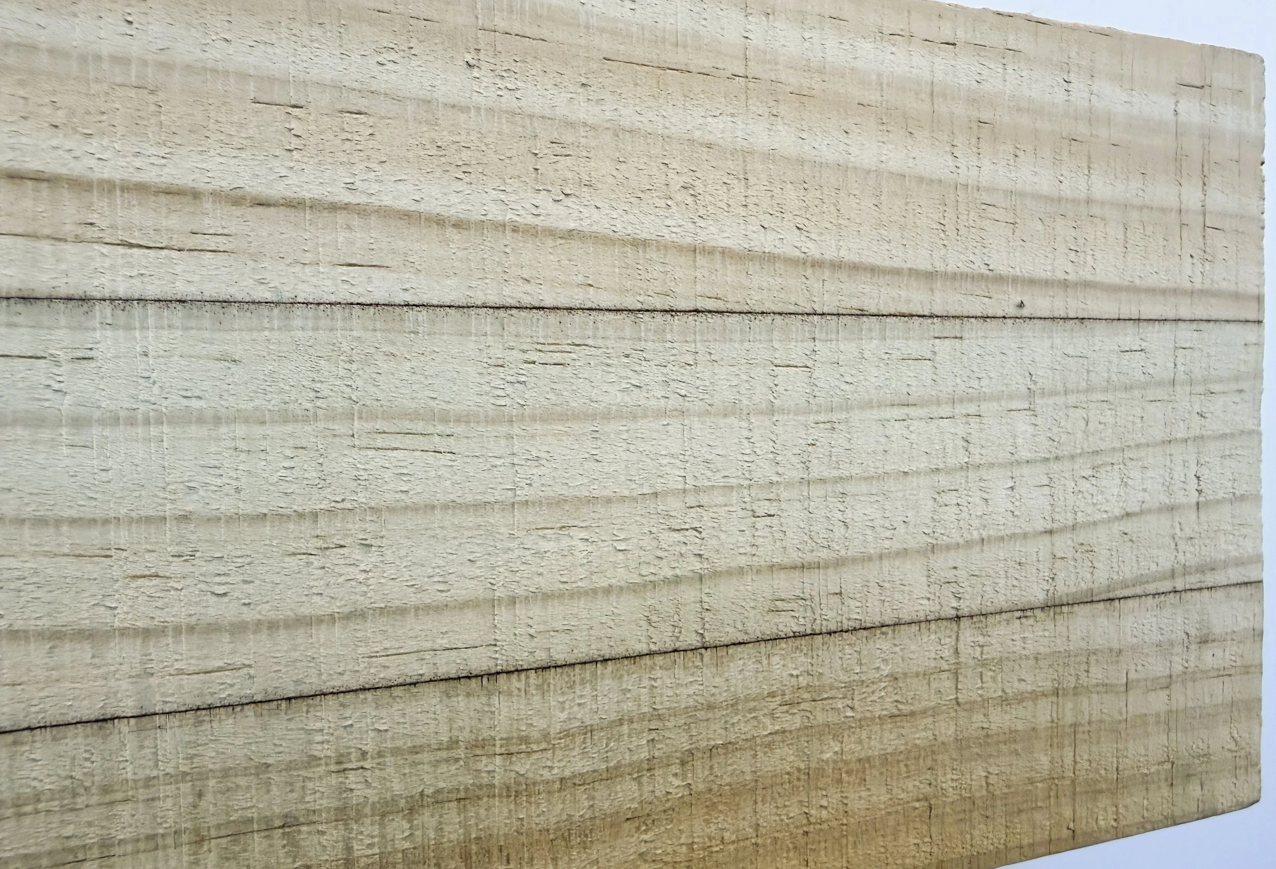 Close-up image of stacked wooden planks with visible wood grain and natural beige color.